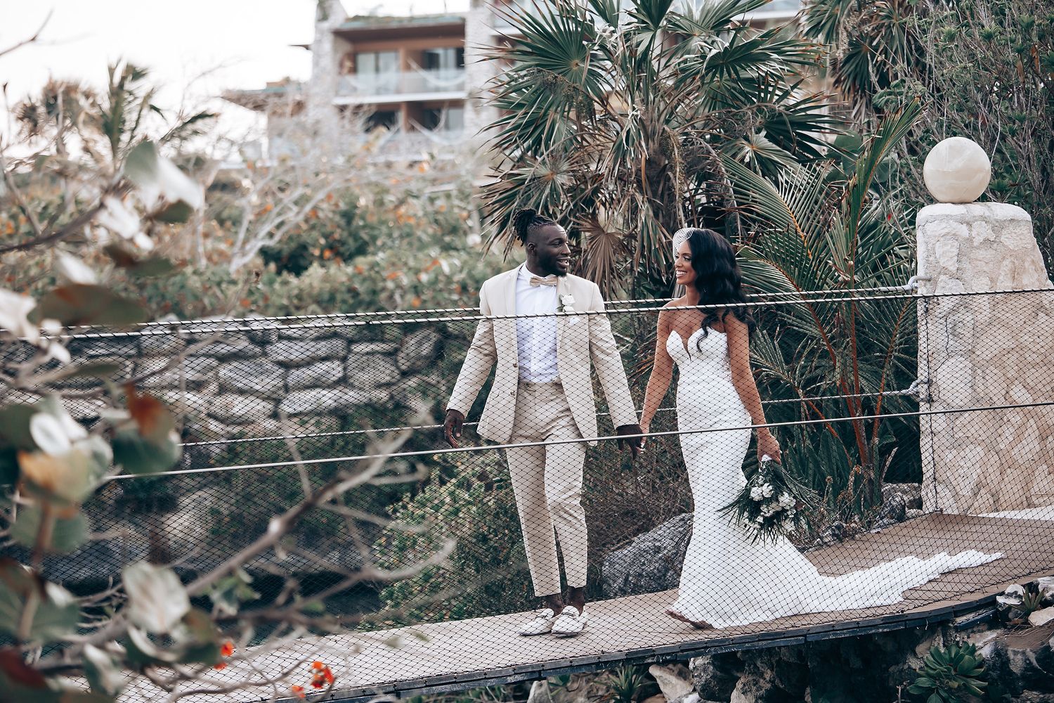 A wedding celebration at a rustic stone venue with palm trees and natural scenery.