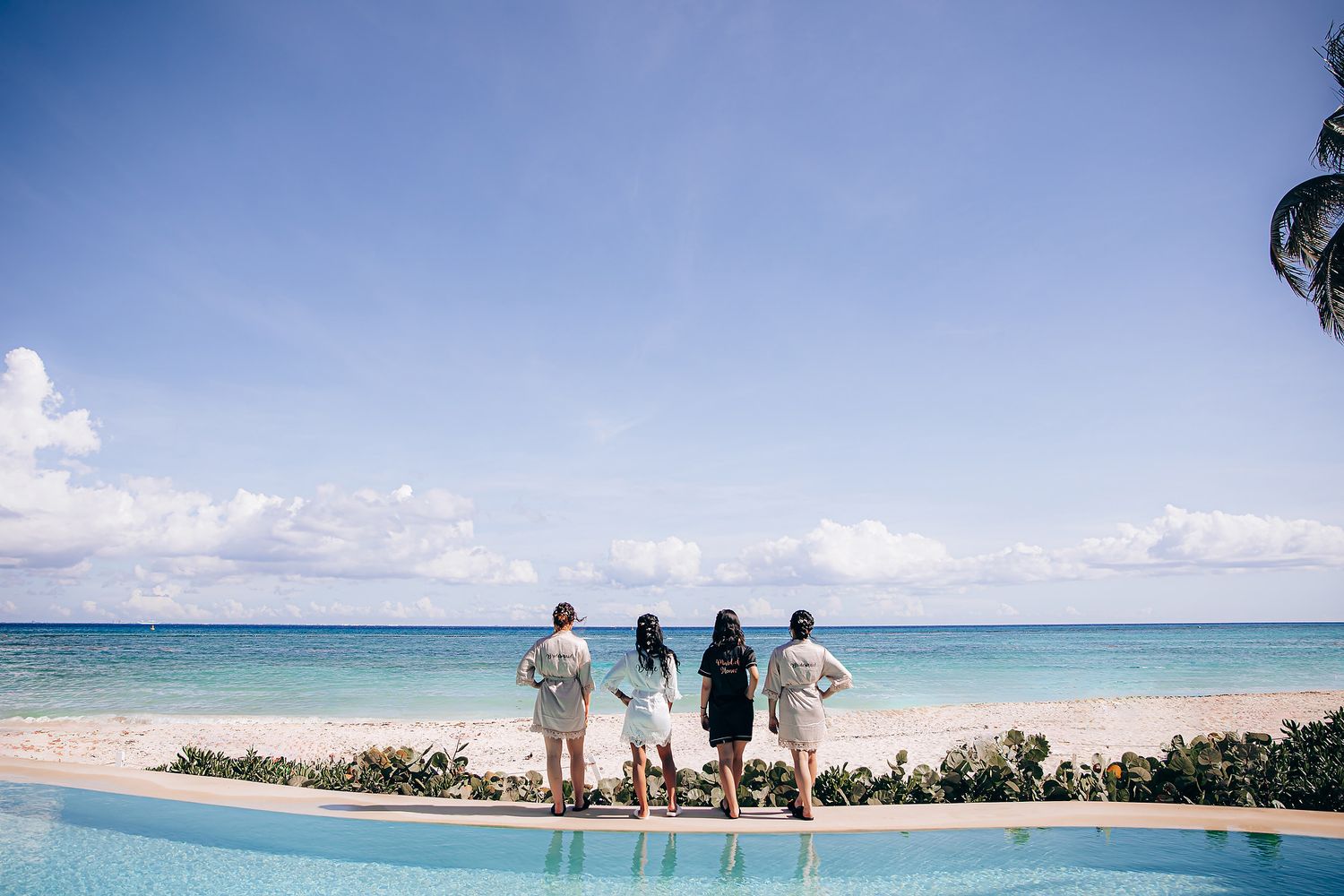 Panoramic view of a tropical beach resort with palm trees and turquoise waters stretching along the coastline.