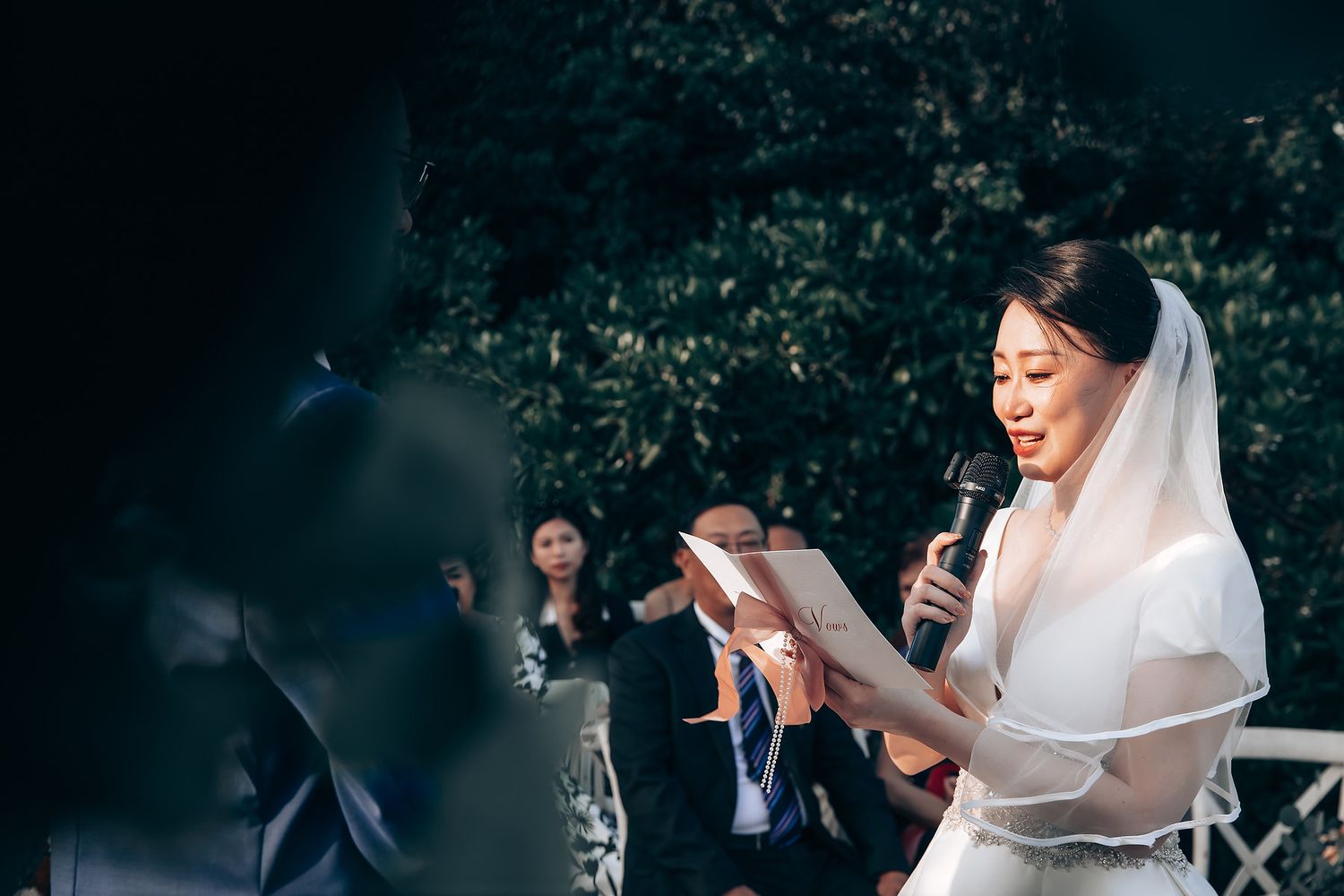 Wedding guests taking photos of a celebration outdoors with phones and cameras.