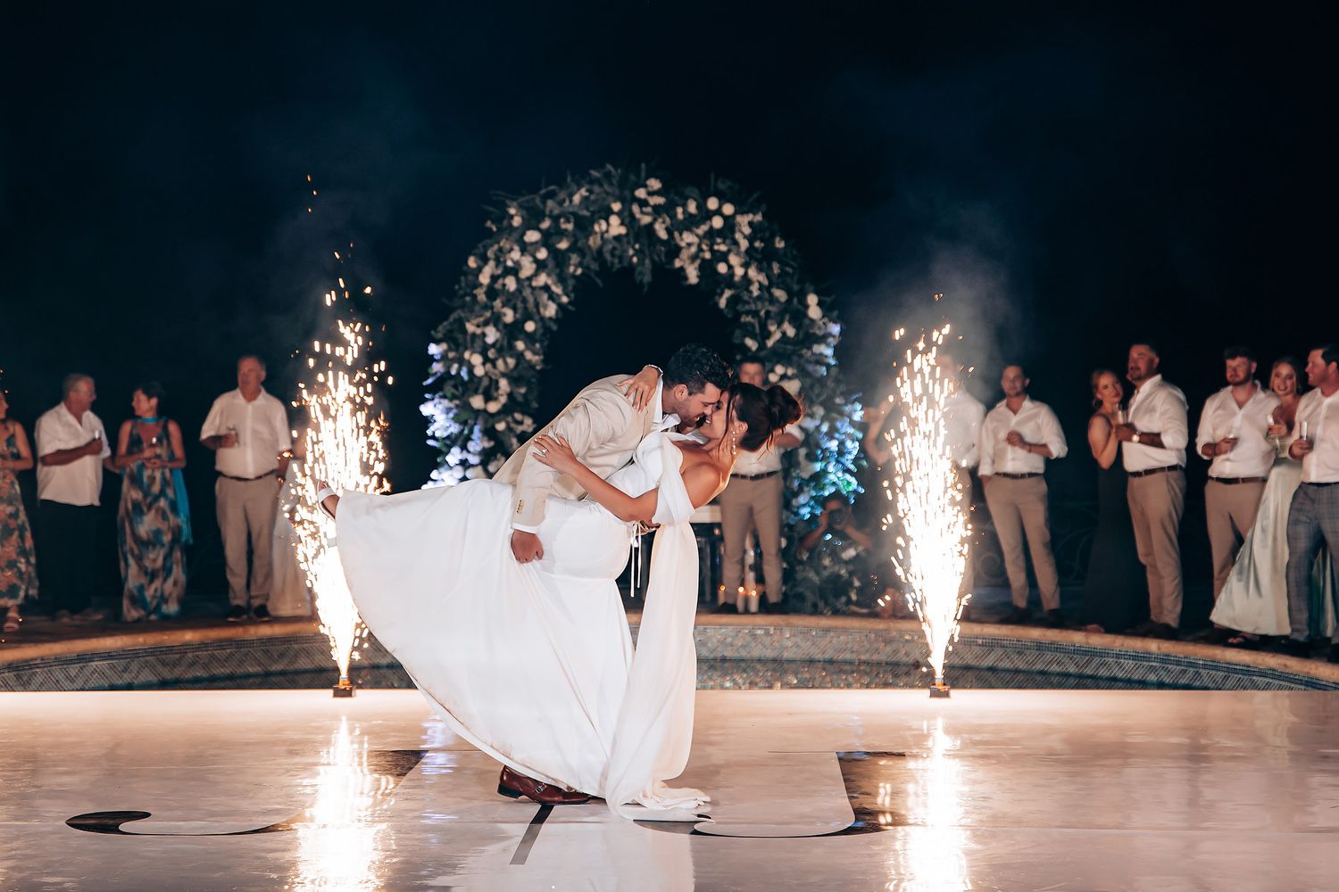 Wedding celebration with sparklers creating a magical nighttime atmosphere on the dance floor.