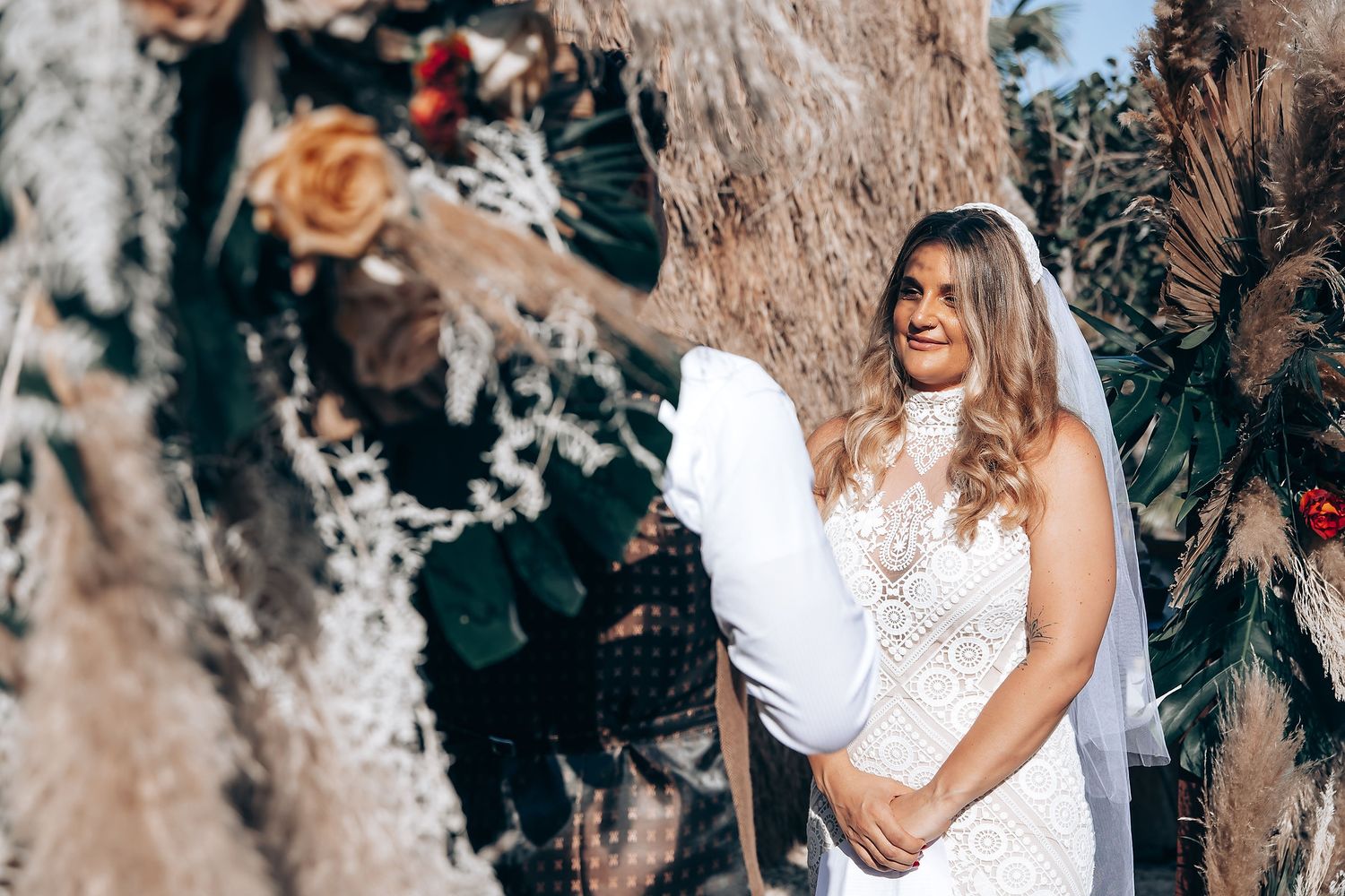 Romantic wedding portraits captured in a tropical setting with boho decor elements.