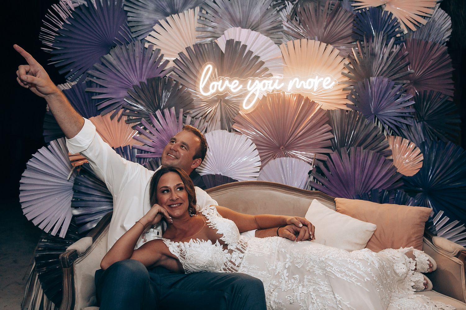 Wedding celebration with decorative white paper fan backdrop and party atmosphere.