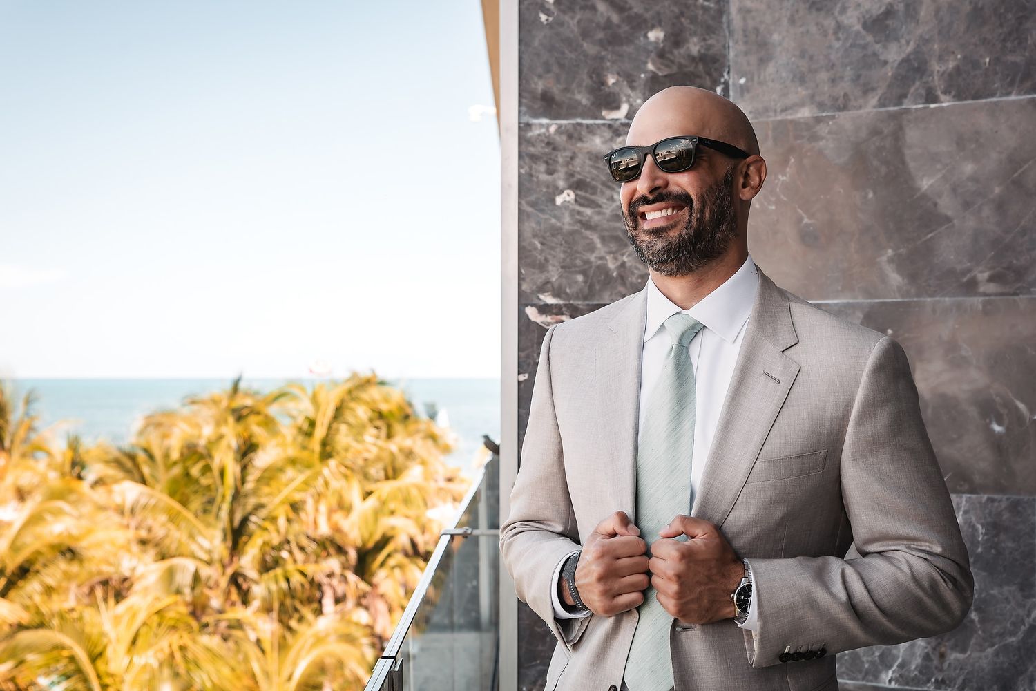 Professional in a light gray suit and sunglasses poses confidently against an urban backdrop in multiple shots.