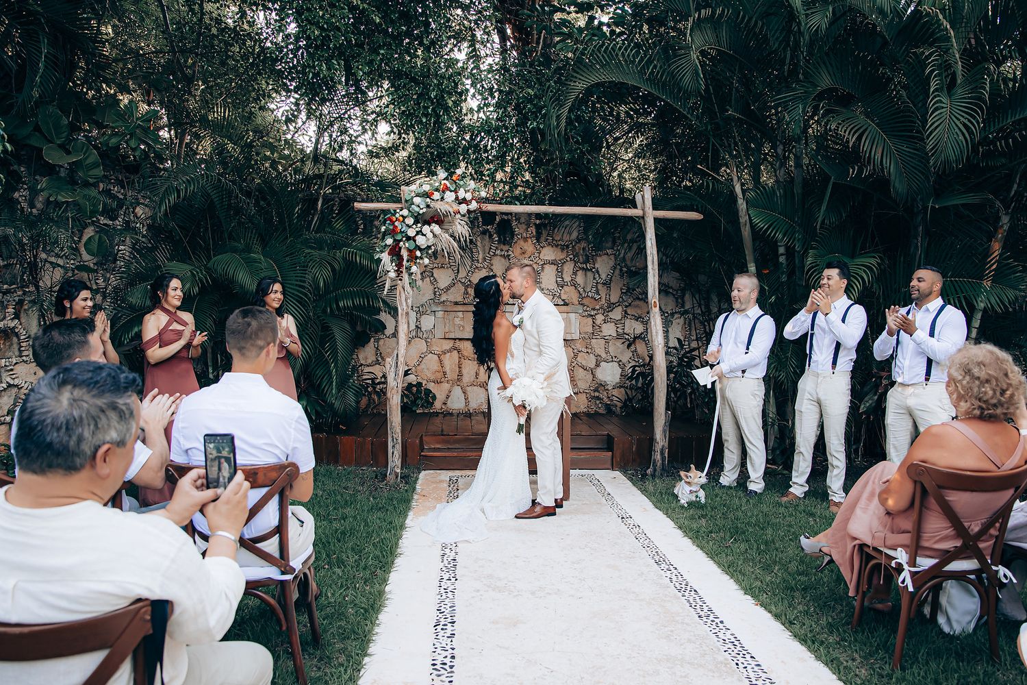 Bride and groom kiss during Mahekal Beach garden wedding ceremony