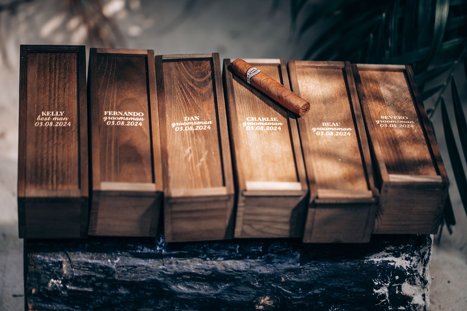 Row of vintage wooden boxes with text arranged on dark surface.