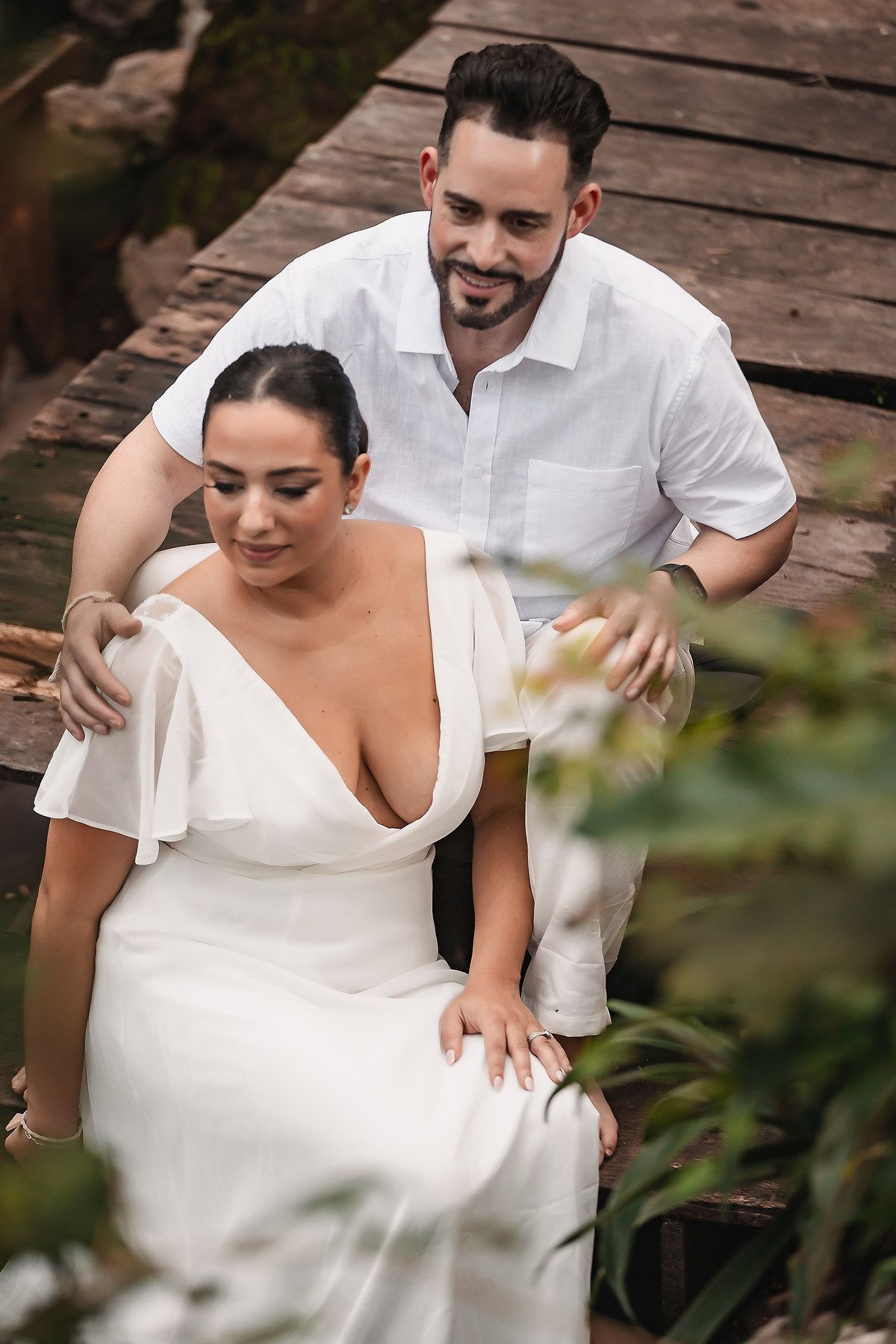 Intimate moment captured during destination wedding on wooden platform.