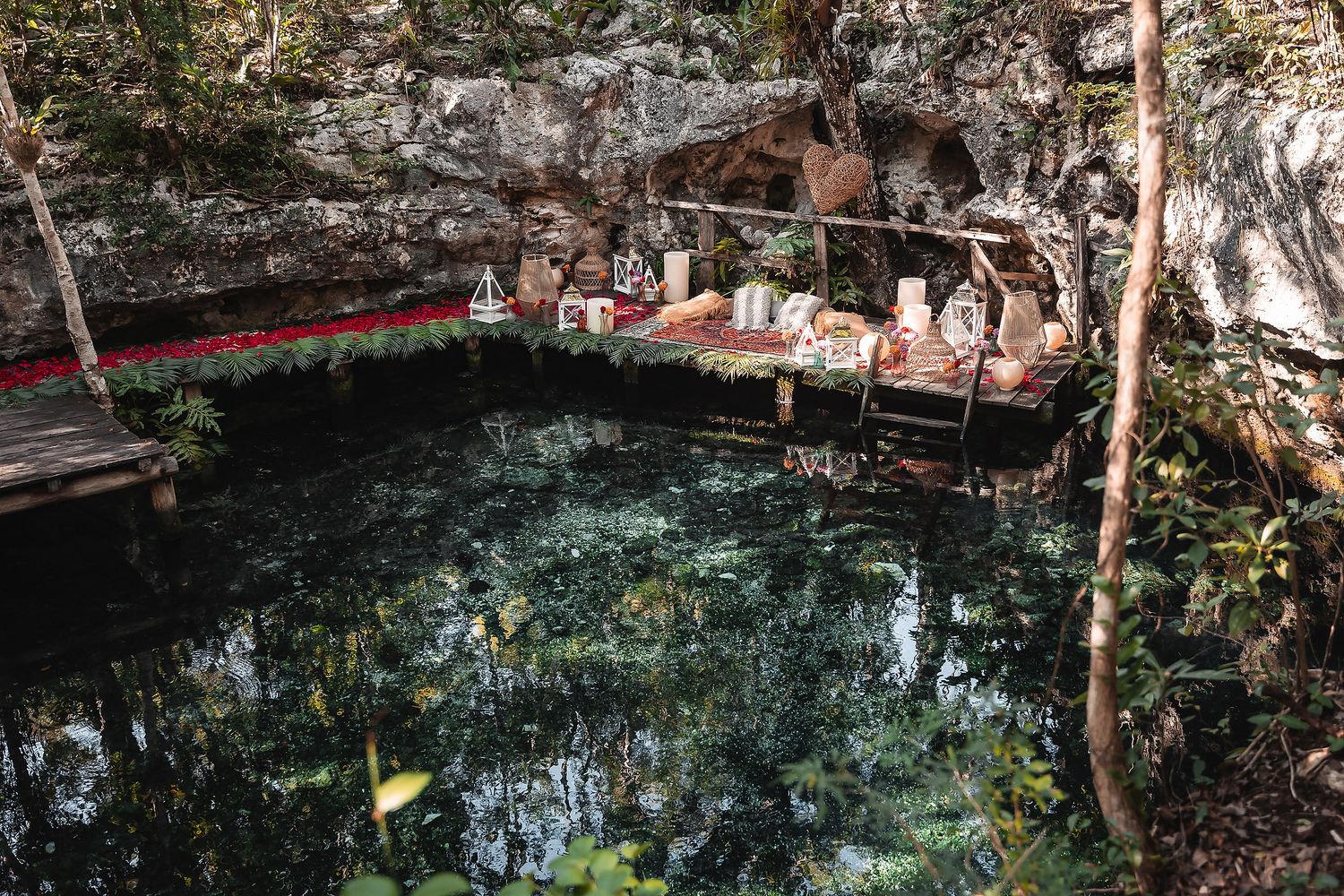 Romantic cave picnic setup with red accents alongside pristine turquoise waters.