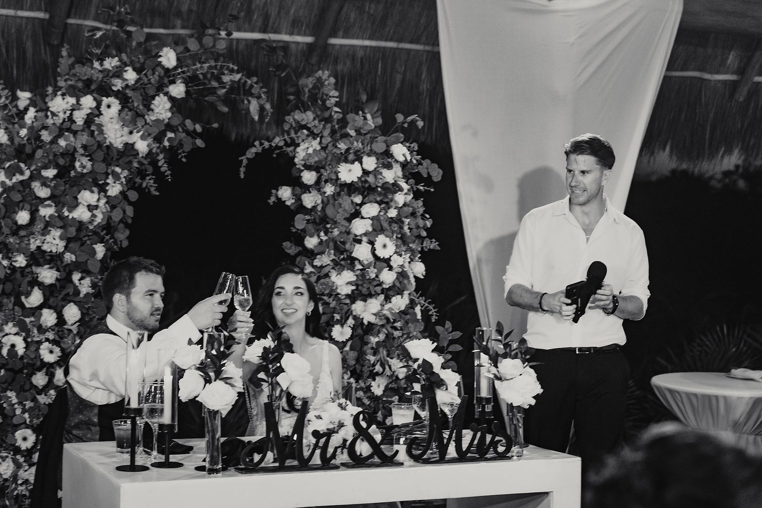 Black and white wedding reception photos with floral arrangements and speeches.
