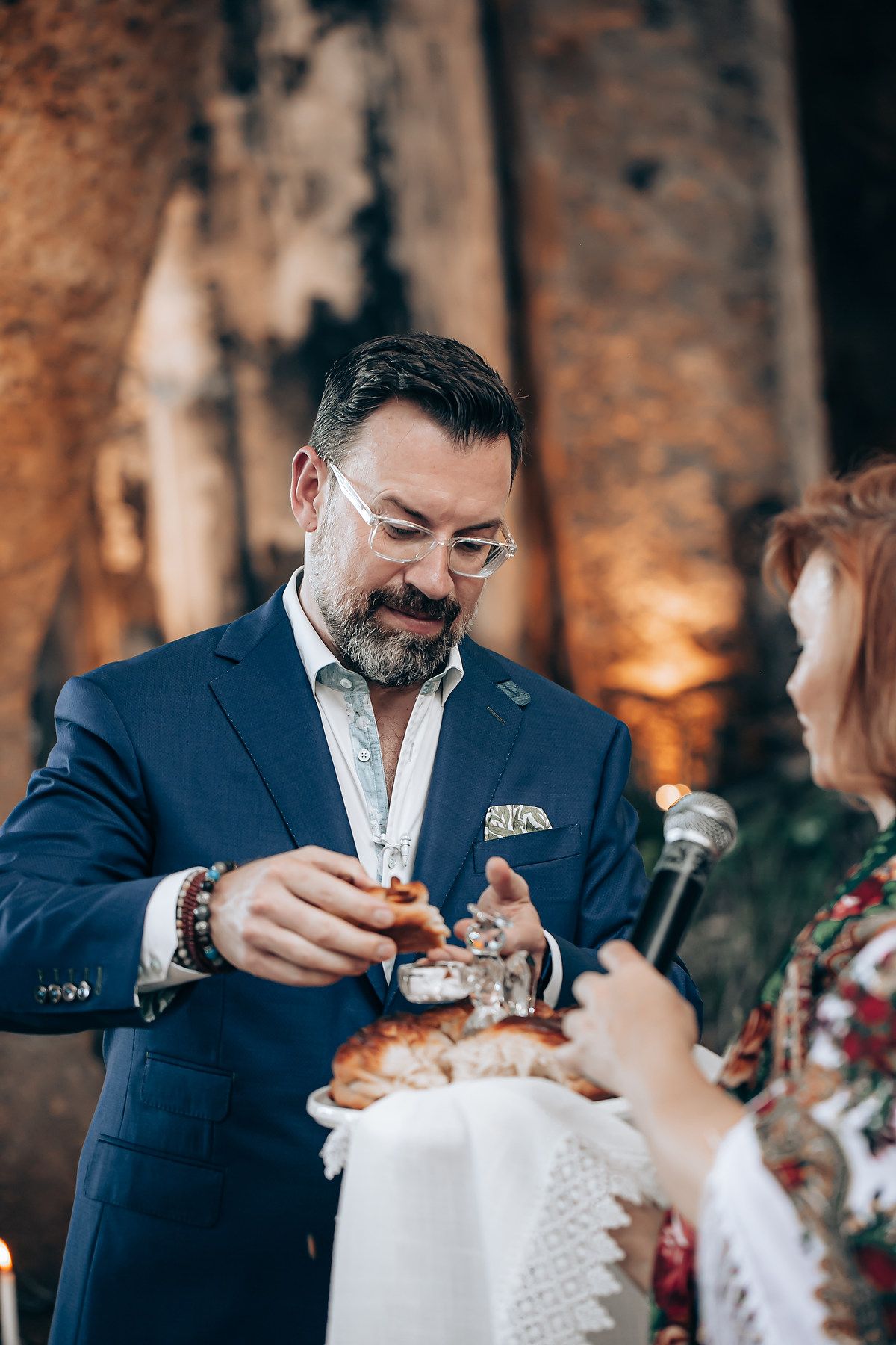 A couple shares an intimate moment during a wedding toast with champagne glasses in a rustic venue.