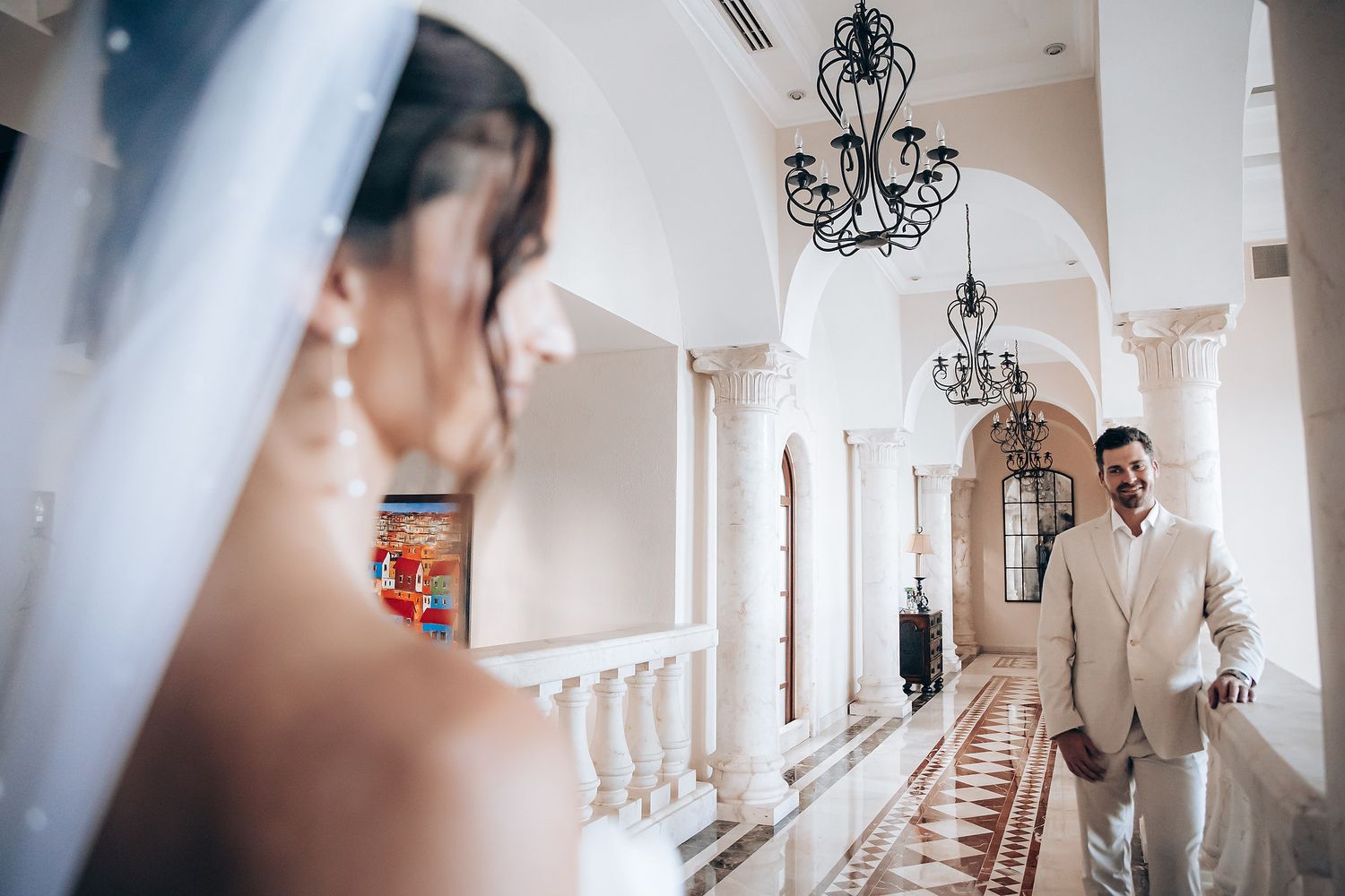 A series of elegant wedding photos showing moments in a bright white venue with ornate chandeliers and natural lighting.