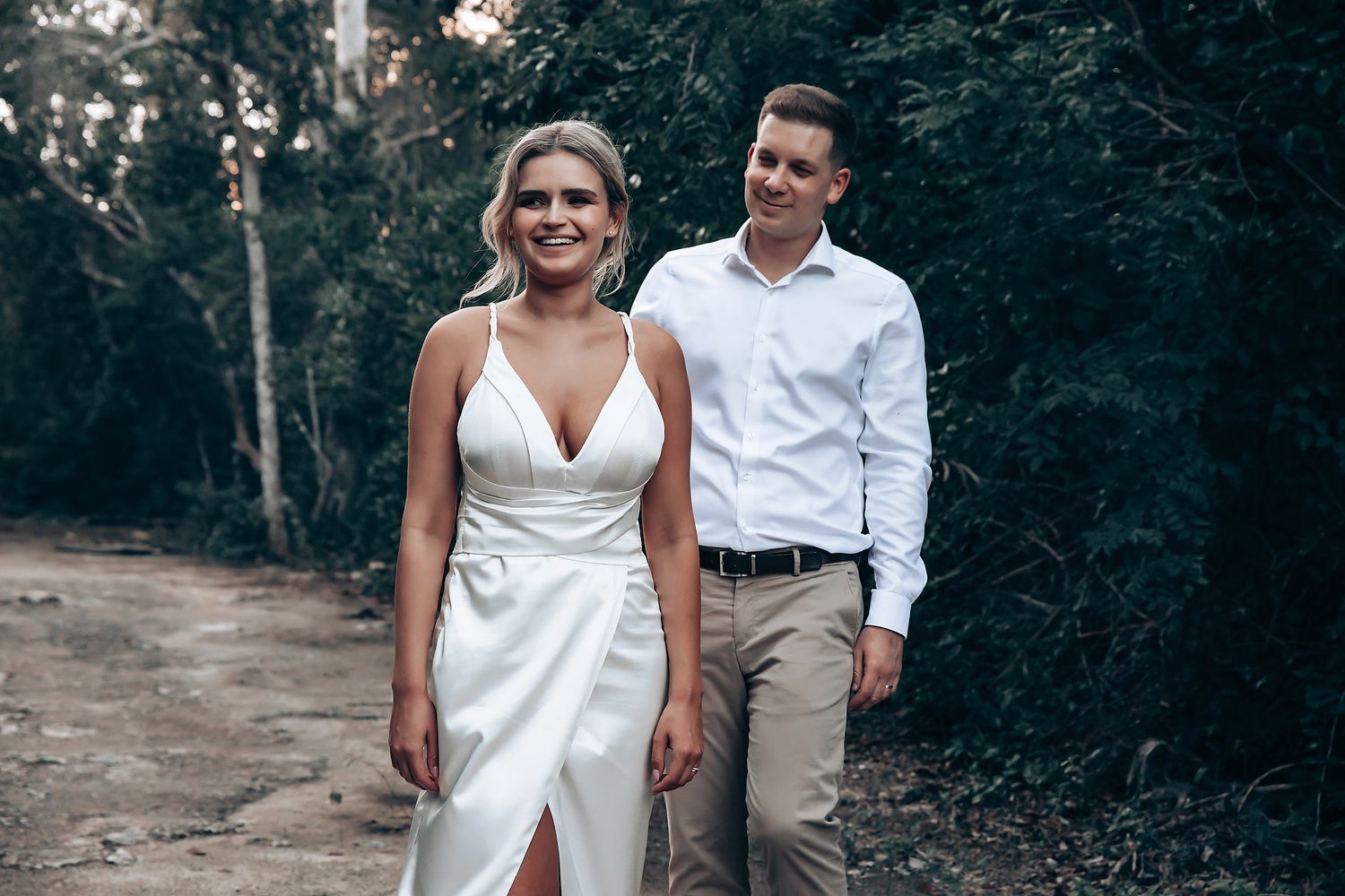 Couple walking together through a scenic wooded path.