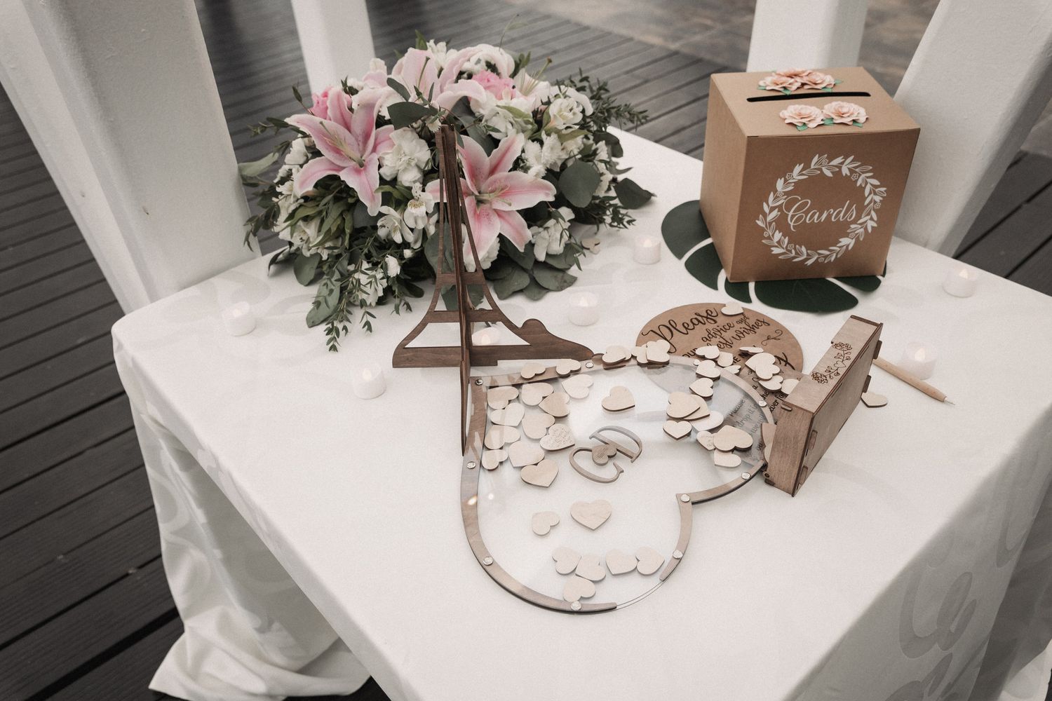 Elegant wedding gift table with pink lily bouquet, wooden card box, and heart-shaped guest book.