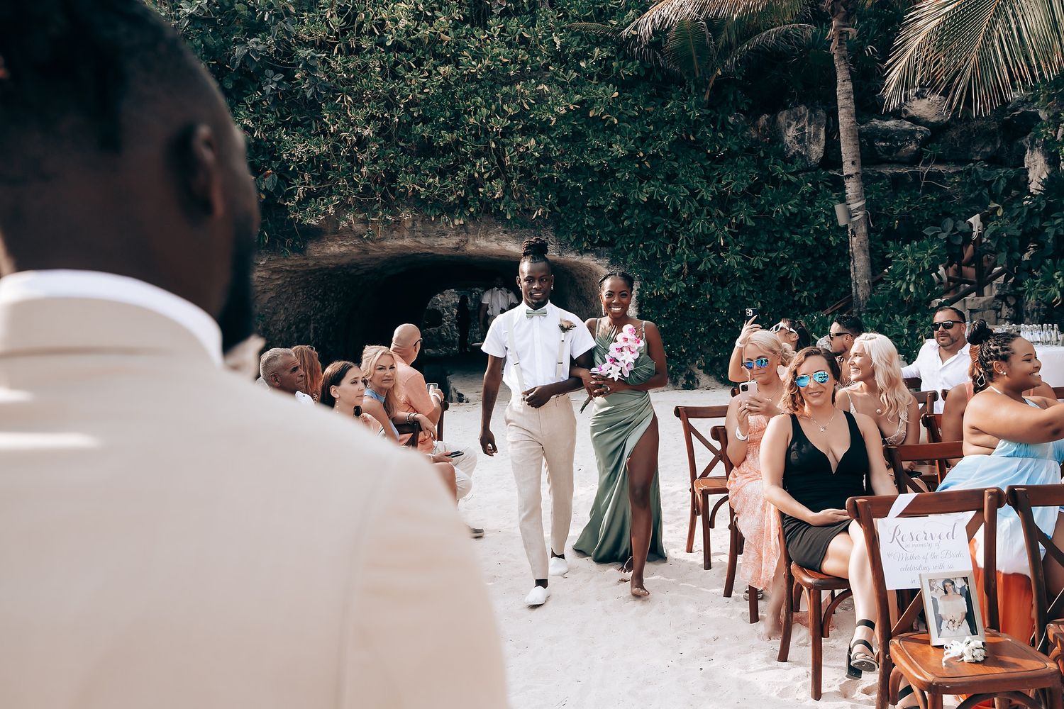 Wedding reception setup outdoors with tables and chairs under natural lighting.
