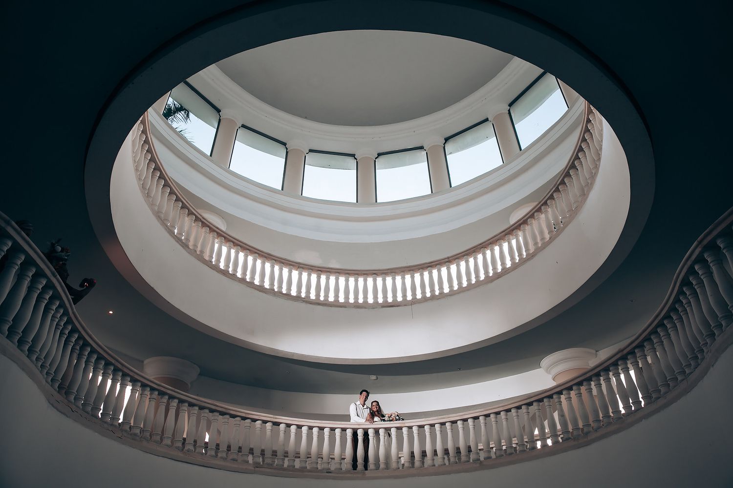 Architectural detail of a circular skylight dome with ornate trim in a white ceiling.