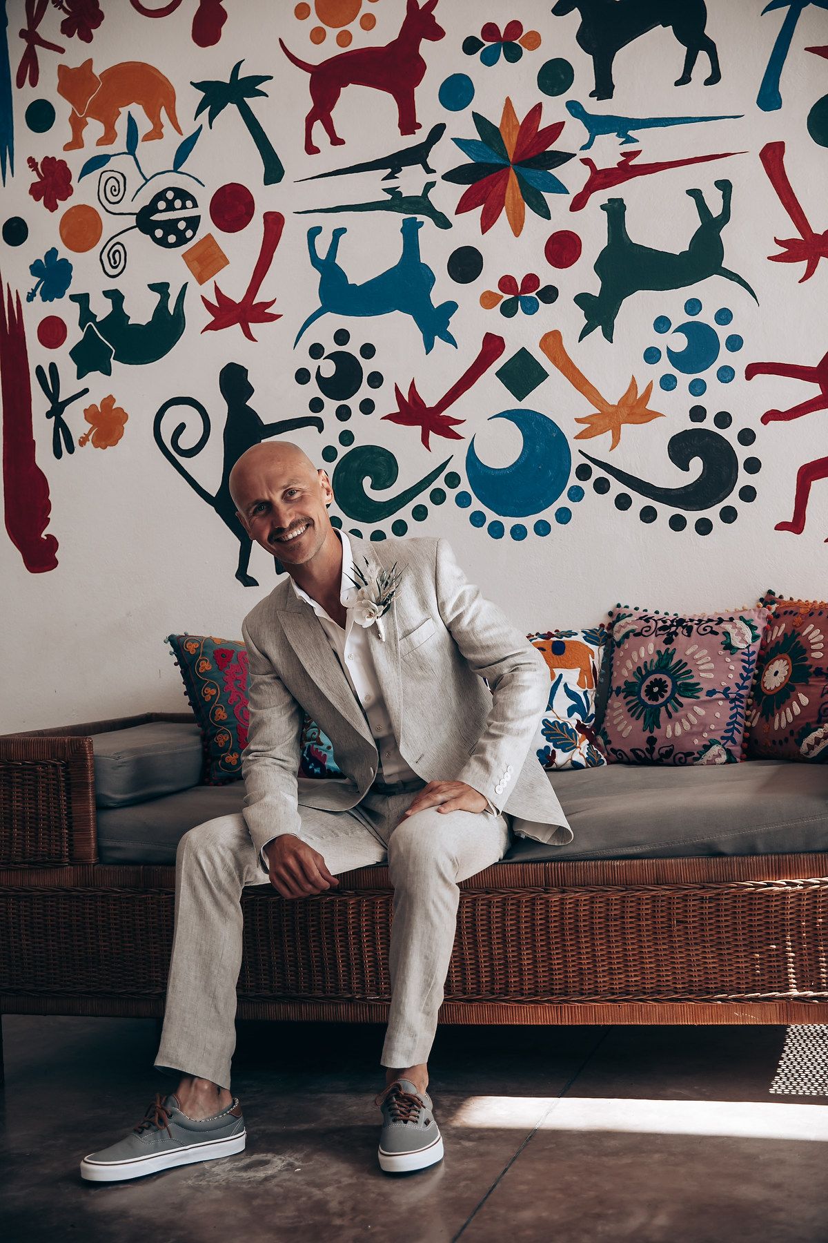 Colorful wall mural with whimsical patterns serves as backdrop for seating area.