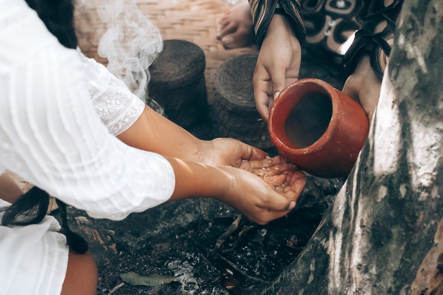 Wedding ceremony participants performing a traditional ritual with clay vessels.