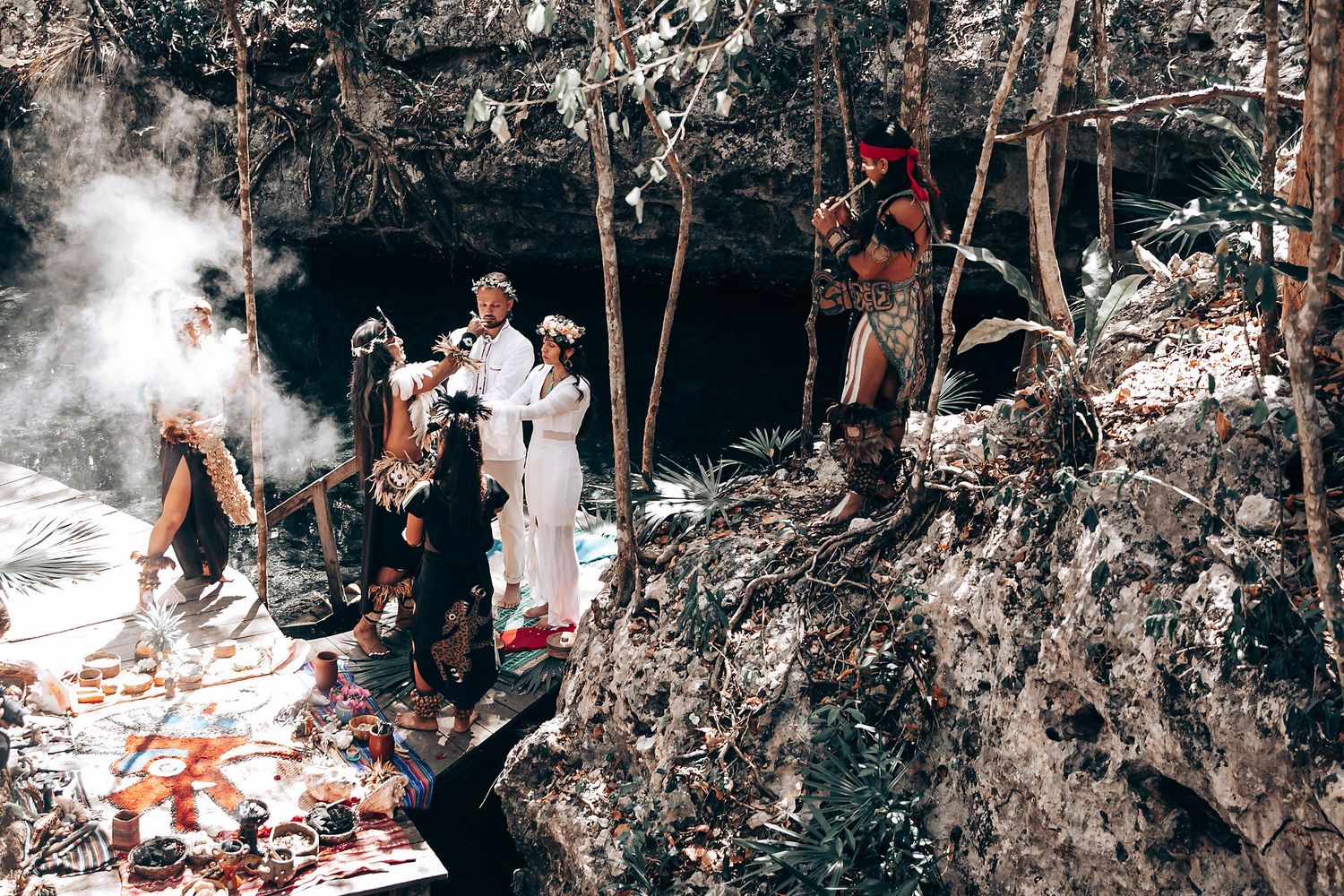 Outdoor forest wedding ceremony with attendees watching the proceedings among trees.