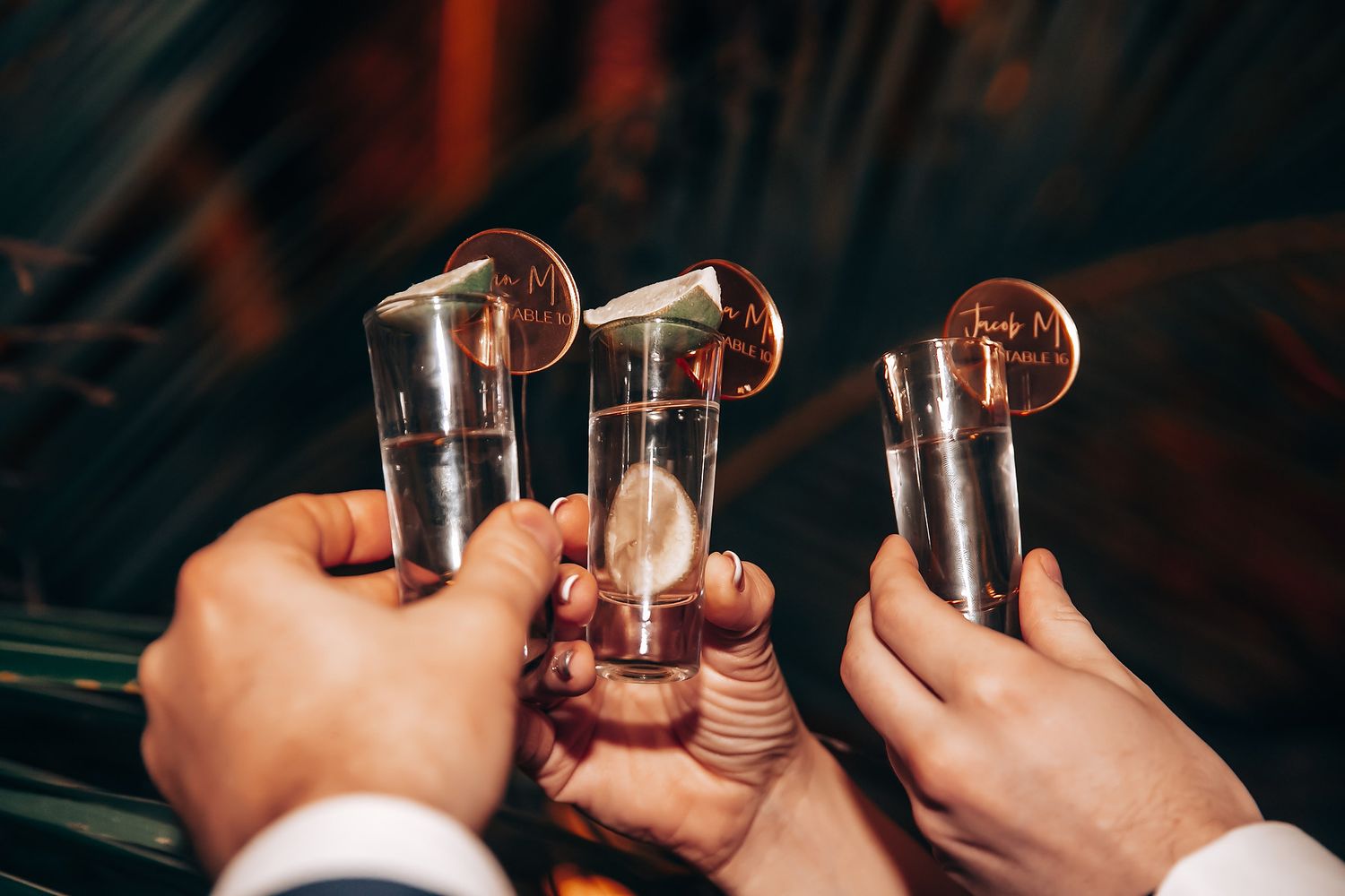 Close-up of hands holding champagne glasses in a celebratory toast.