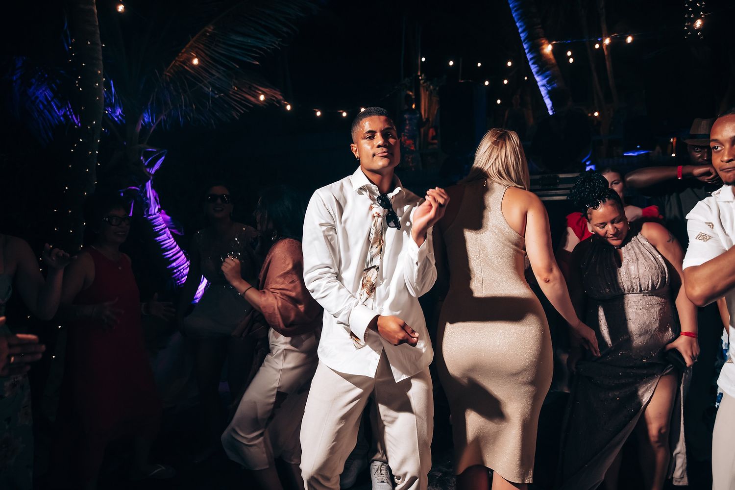Wedding reception dance party with colorful lighting and guests enjoying the celebration.