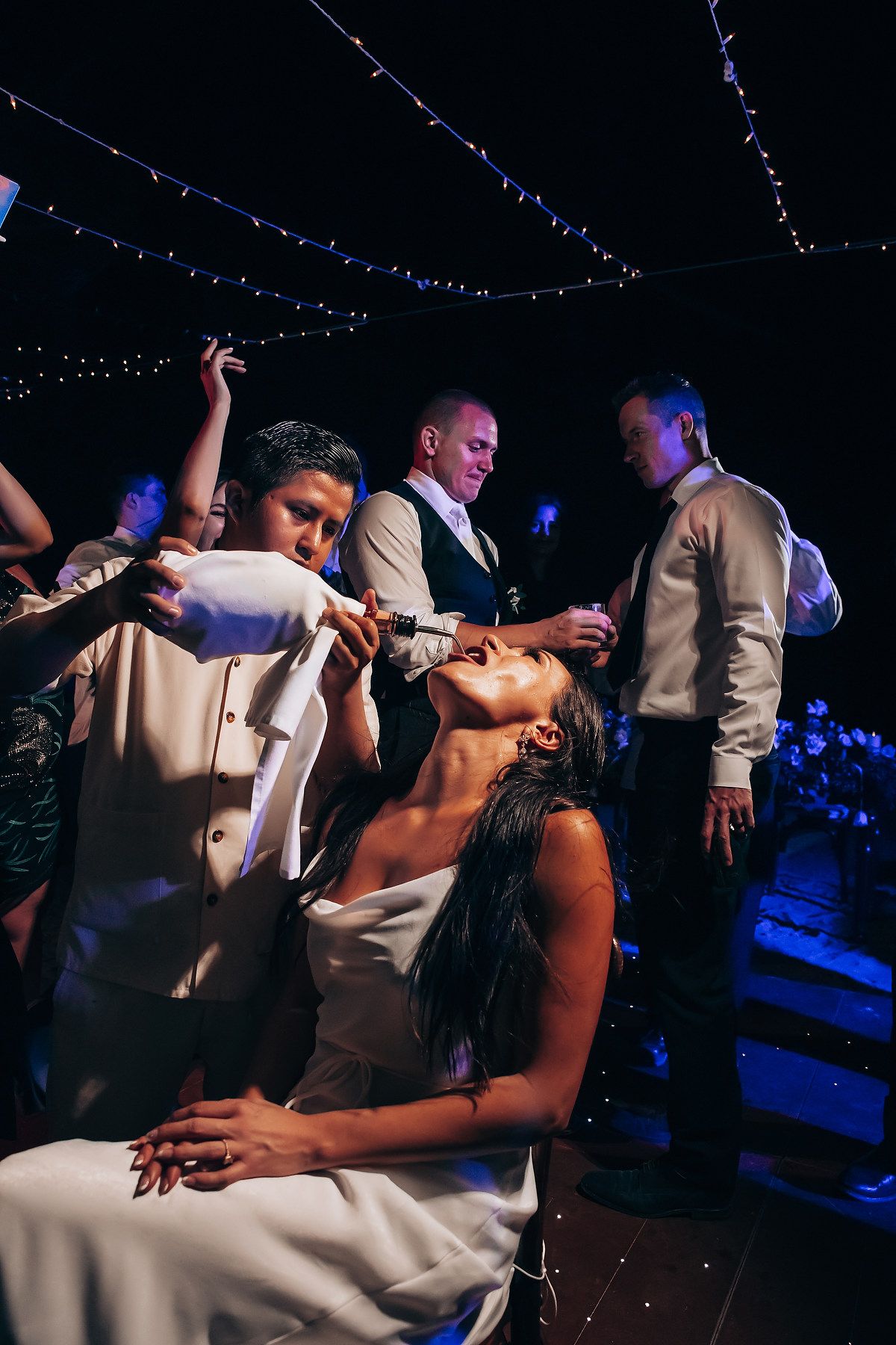 Wedding reception dance party with string lights creating a romantic atmosphere.