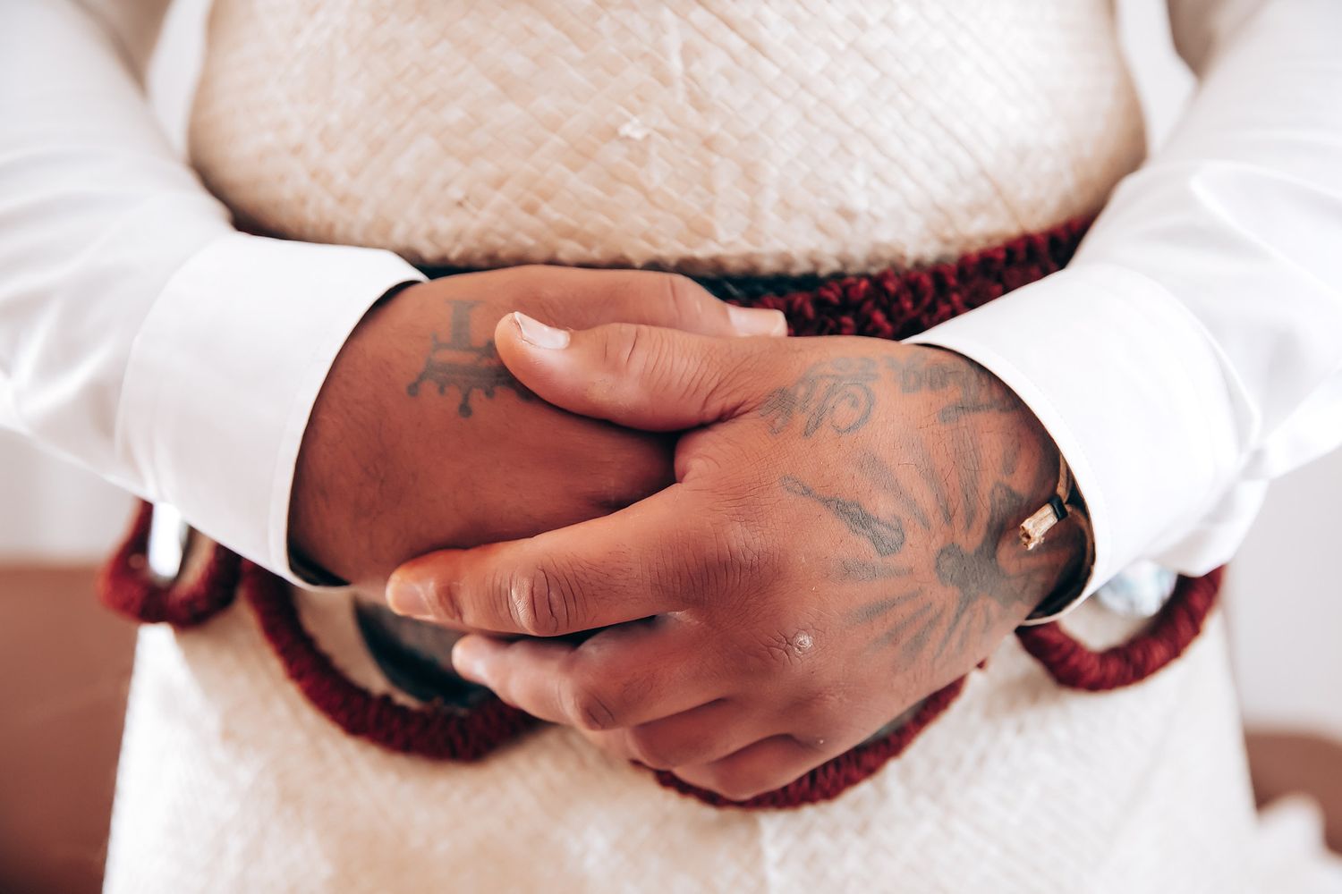 Close-up details of wedding preparations showing hands and decorative elements.