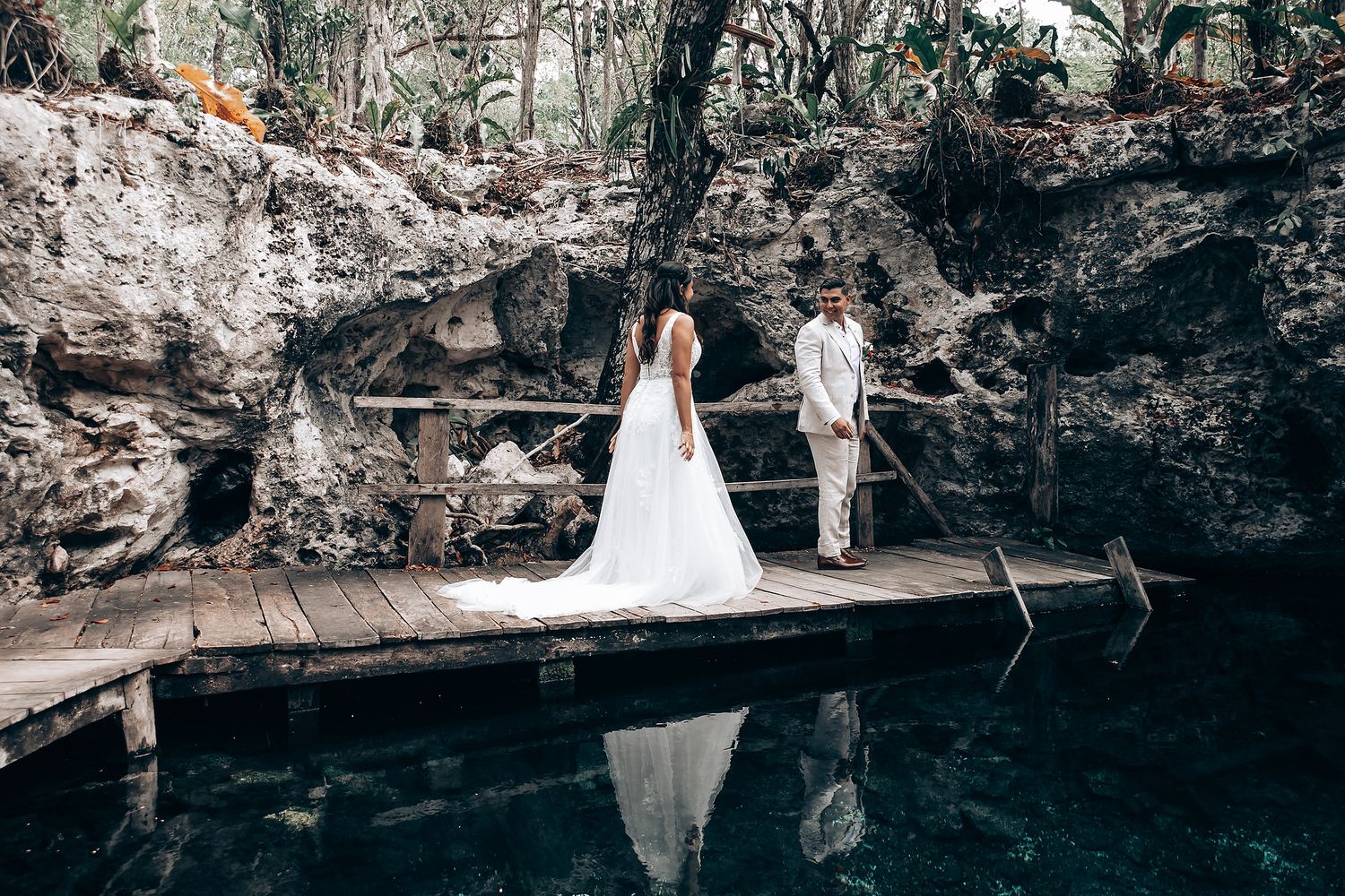 Wedding ceremony setup in a dramatic cave cenote with natural rock formations.
