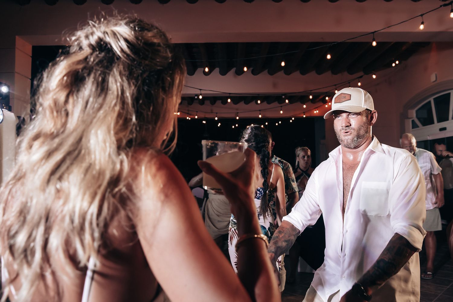An image of a couple dancing at a wedding reception with other guests in the background.
