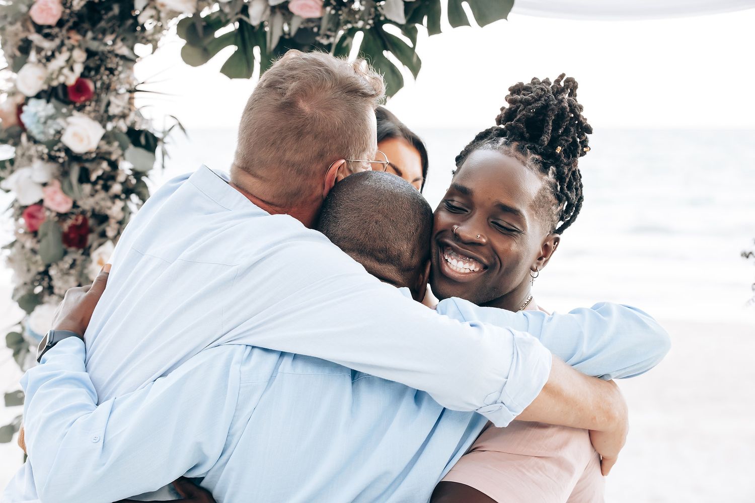 Image of a couple embracing at a beach wedding ceremony.