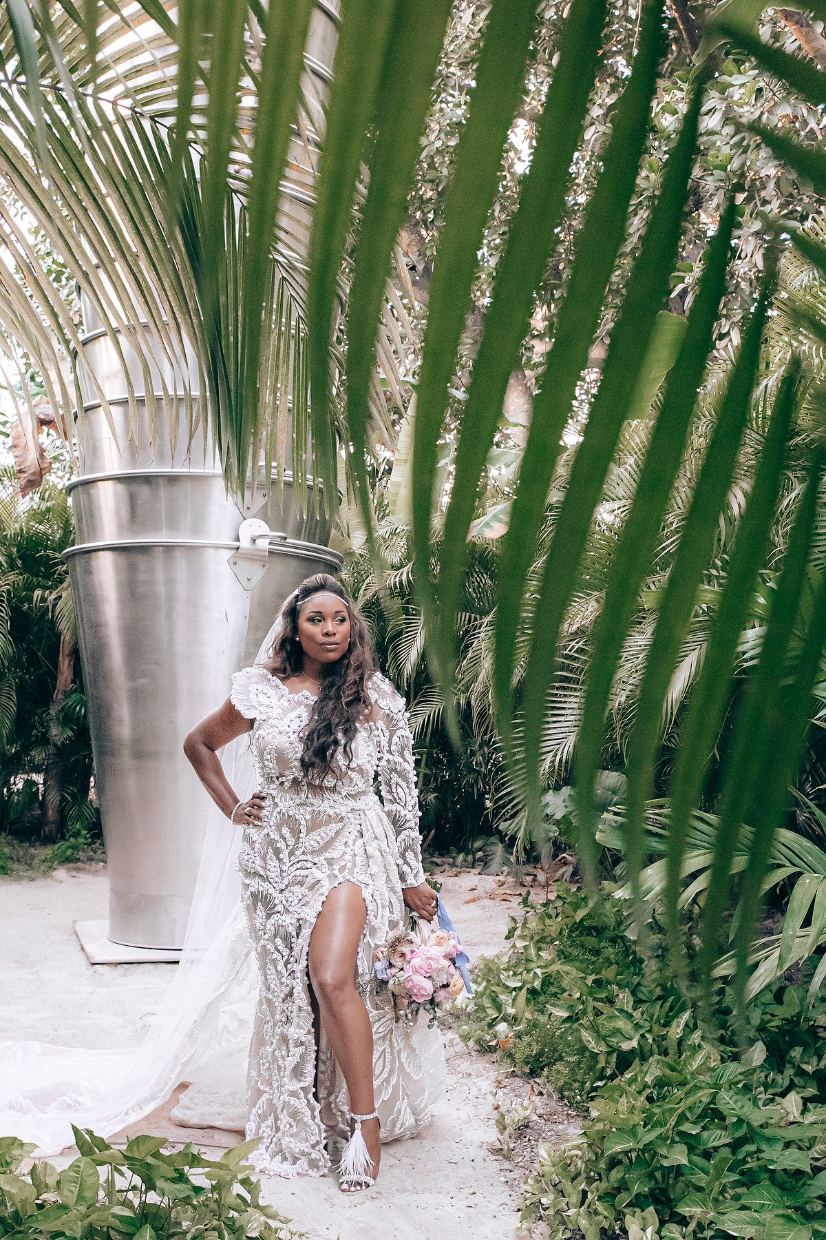A series of photos showing someone posing in a white lace dress among tropical palm fronds and garden scenery.