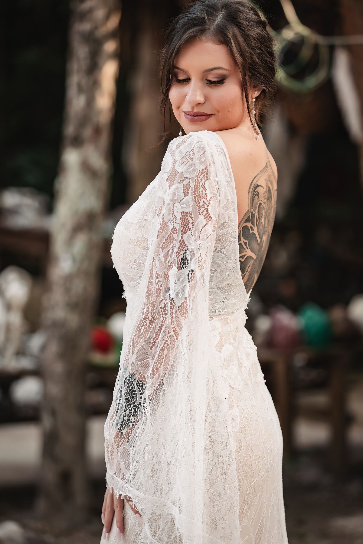 Detailed view of an intricate lace wedding dress with sheer long sleeves and delicate embroidery.