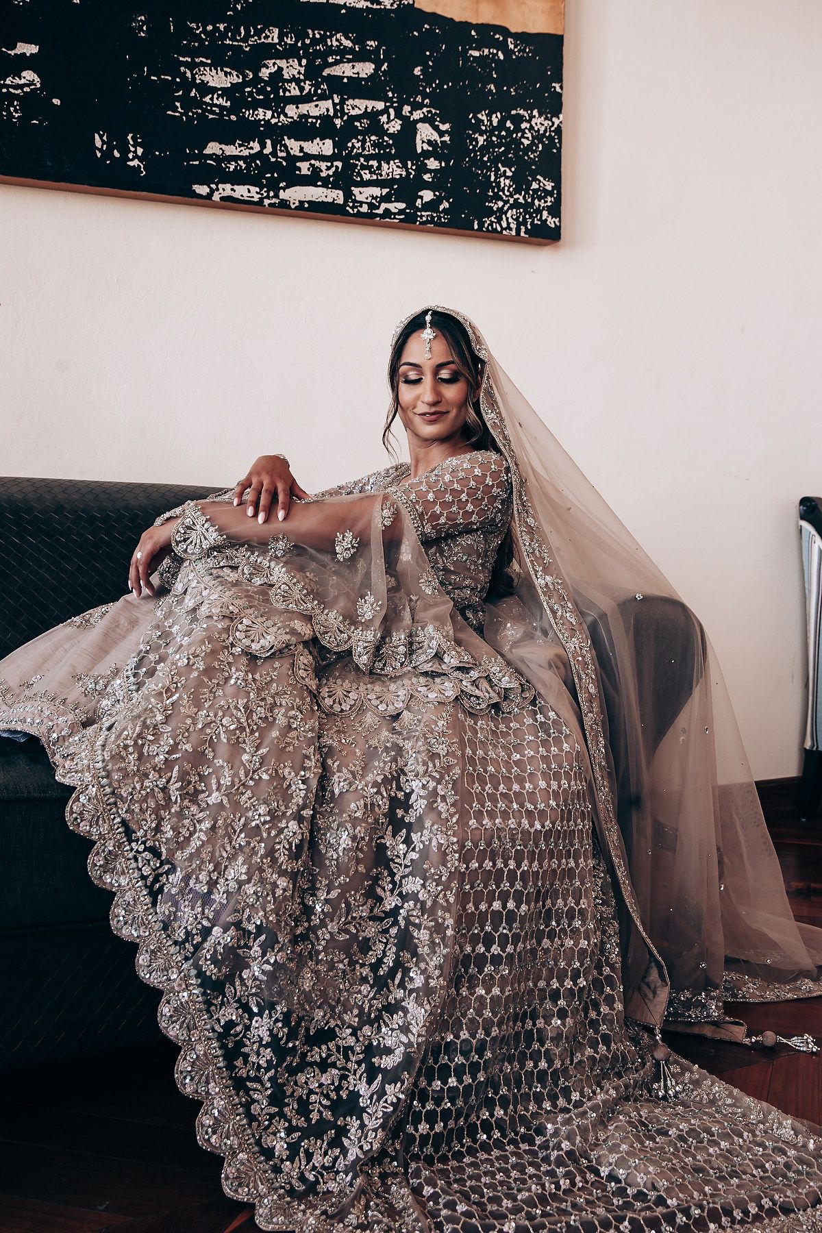 Ornate beaded wedding dress with intricate lace details spread out on display.