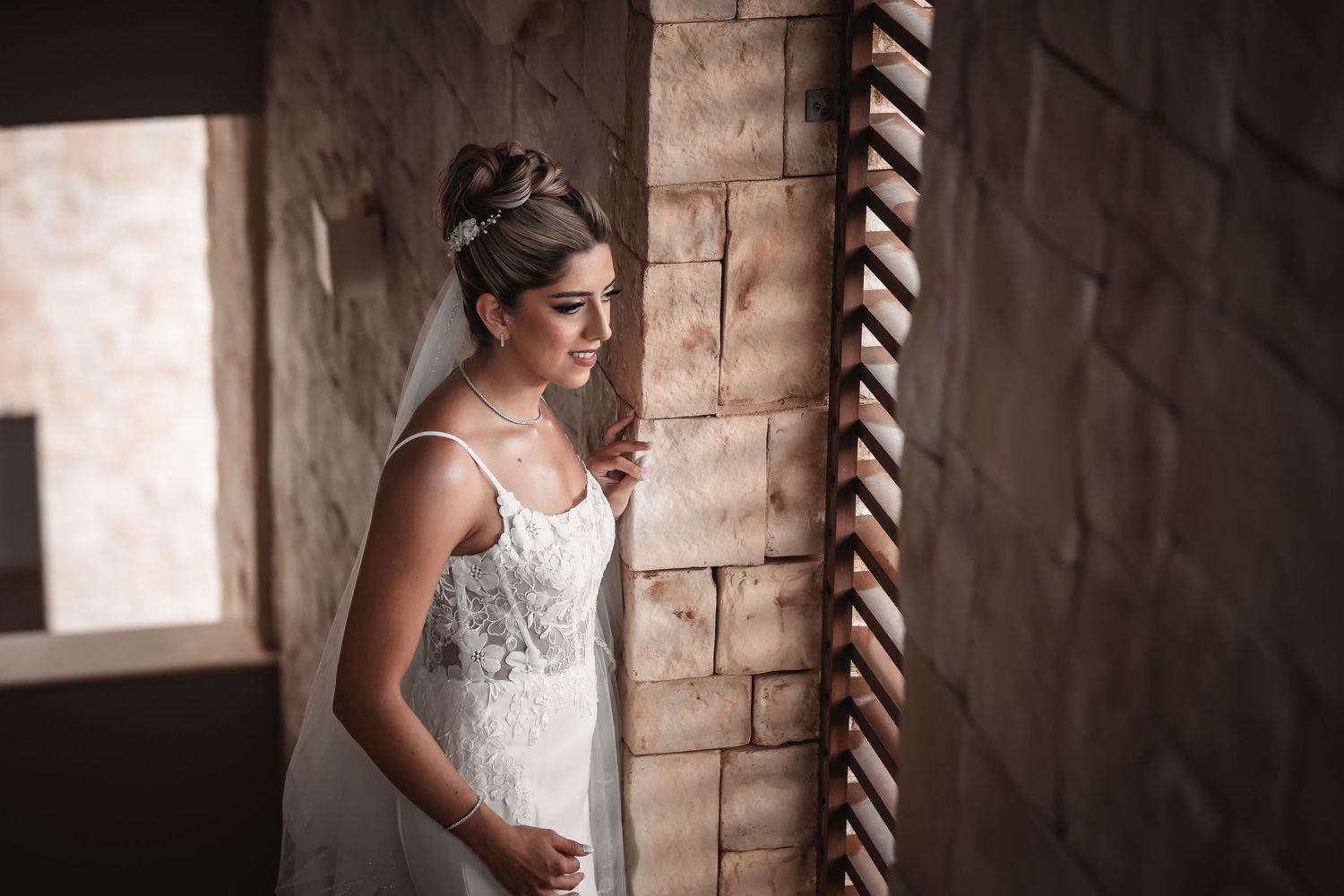 Artistic bridal portraits captured against textured brick walls in natural light.