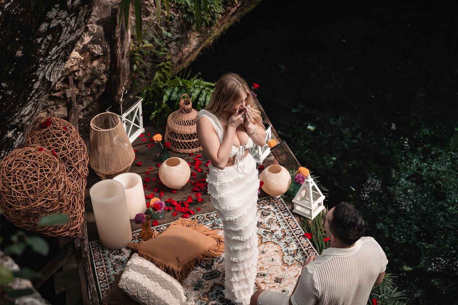 Intimate garden setting decorated with white candles and rustic elements against a dark background.