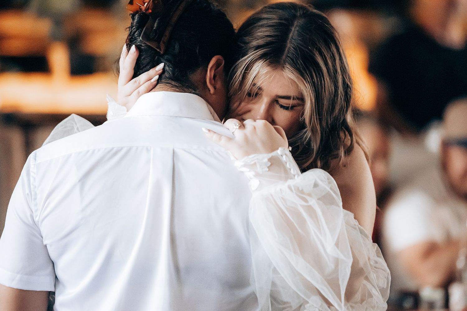 Couples dancing together at a daytime wedding reception in a rustic venue.