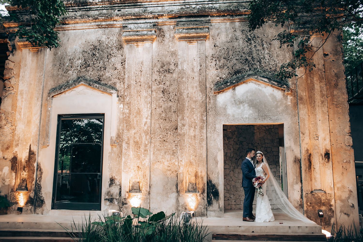 Wedding ceremony setup in rustic stone venue with warm lighting and vintage architectural details.