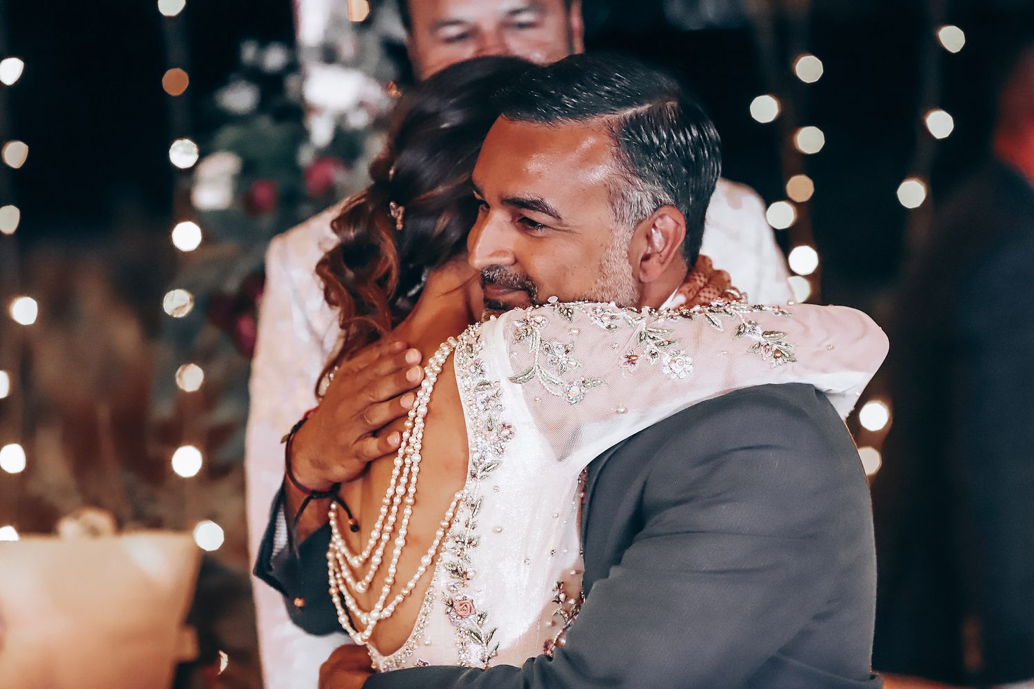 Wedding celebration at night with twinkling lights and guests enjoying the festivities.