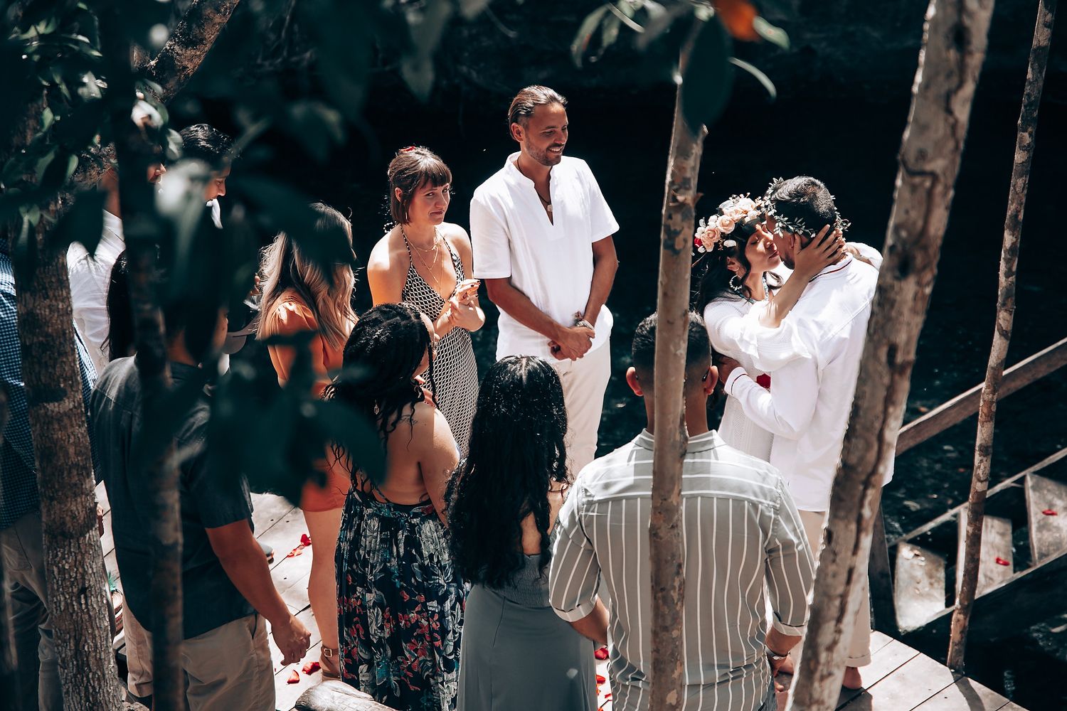 Attendees in white clothing participating in an outdoor cultural ceremony.