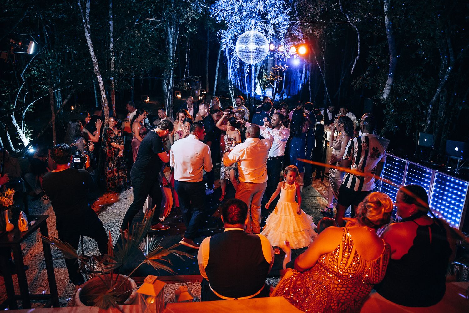 Lively wedding reception dance floor with colorful lighting and dancing guests.