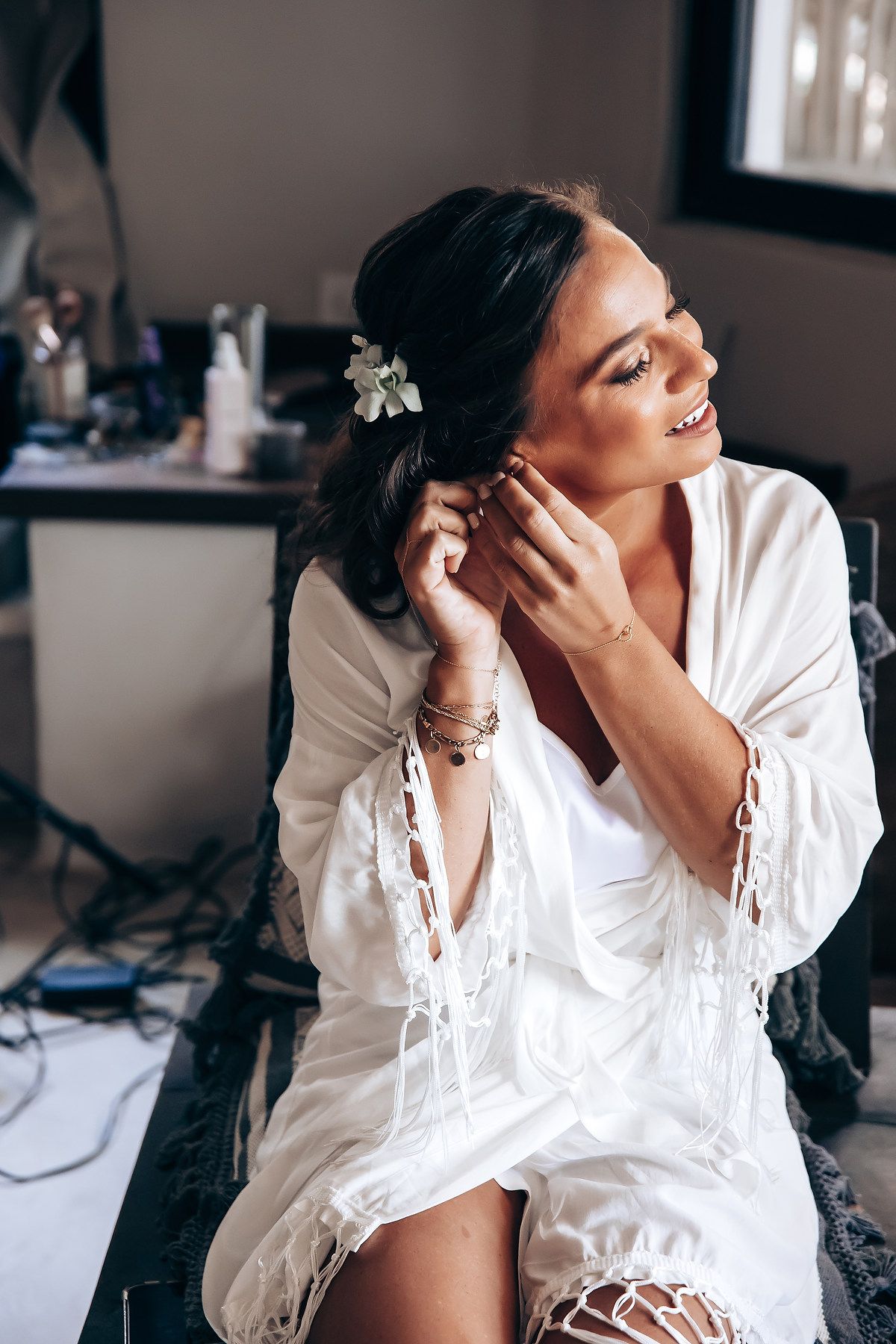 Intimate boudoir photo session featuring a woman in a white button down shirt posing elegantly on a bed.