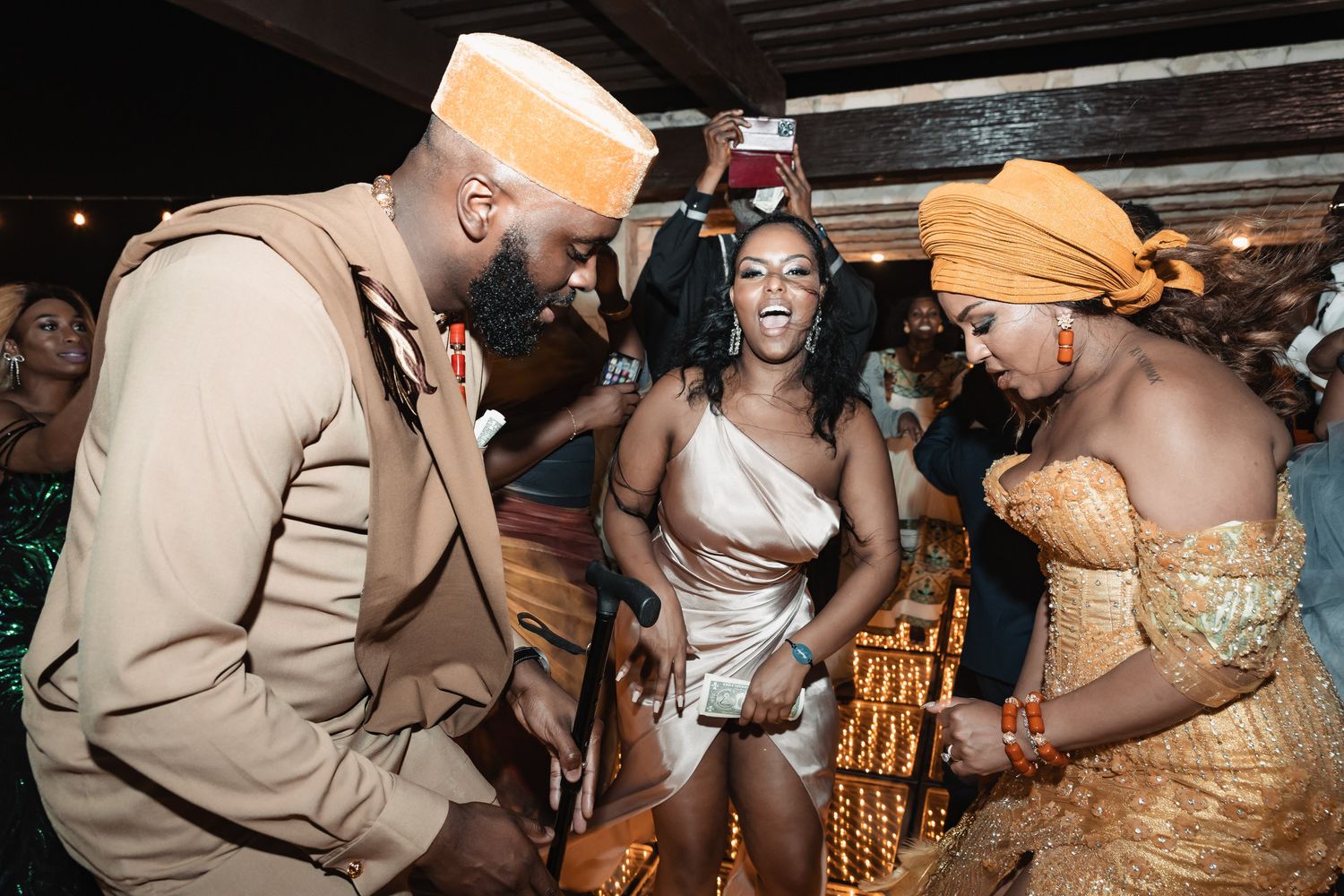 Lively African cultural wedding celebration with guests dancing in traditional attire and vibrant accessories.