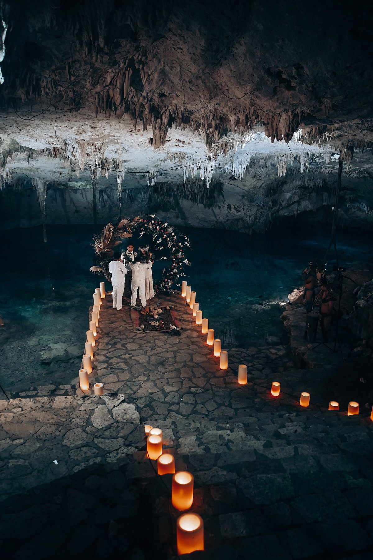 Illuminated pathway in a dark cave with glowing lanterns creating a warm ambiance along stone walkway.