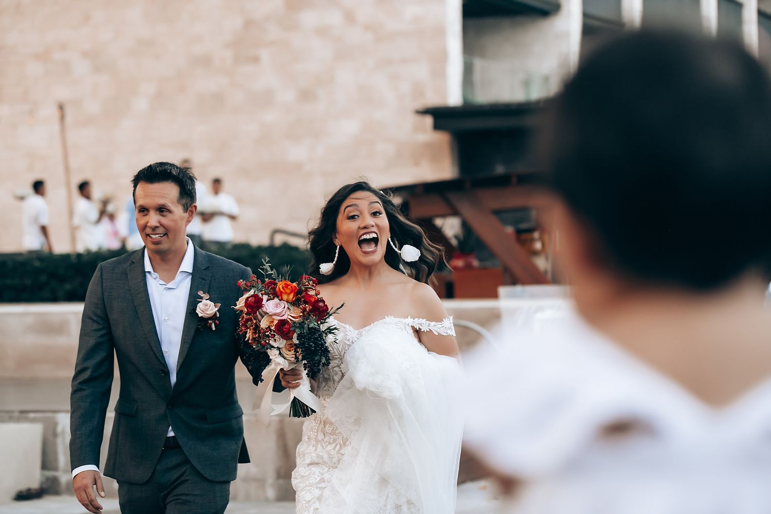 Celebratory moment at a wedding with mariachi band in background.