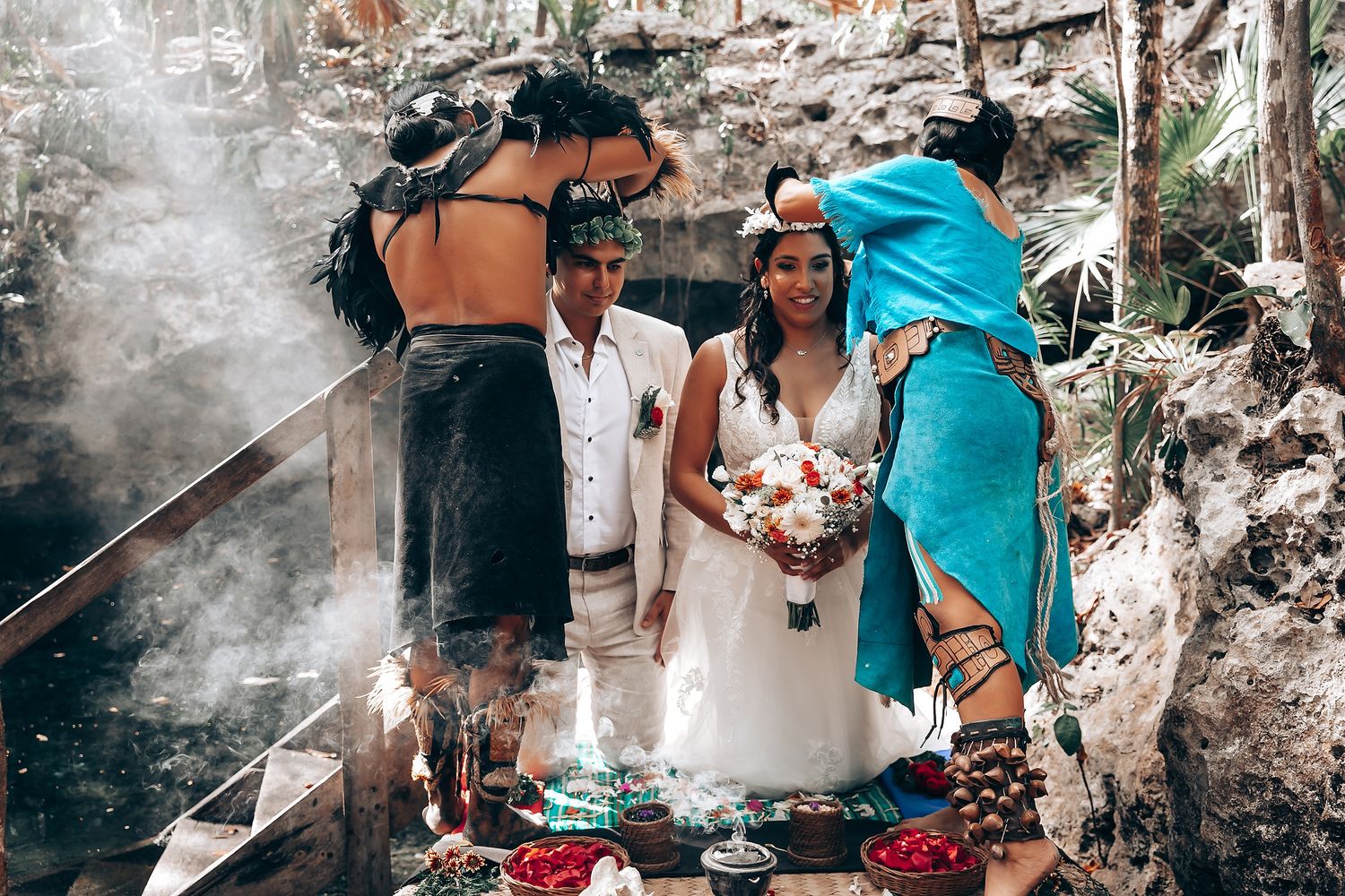 Traditional wedding ceremony takes place in a natural forest setting with decorative smoke elements.