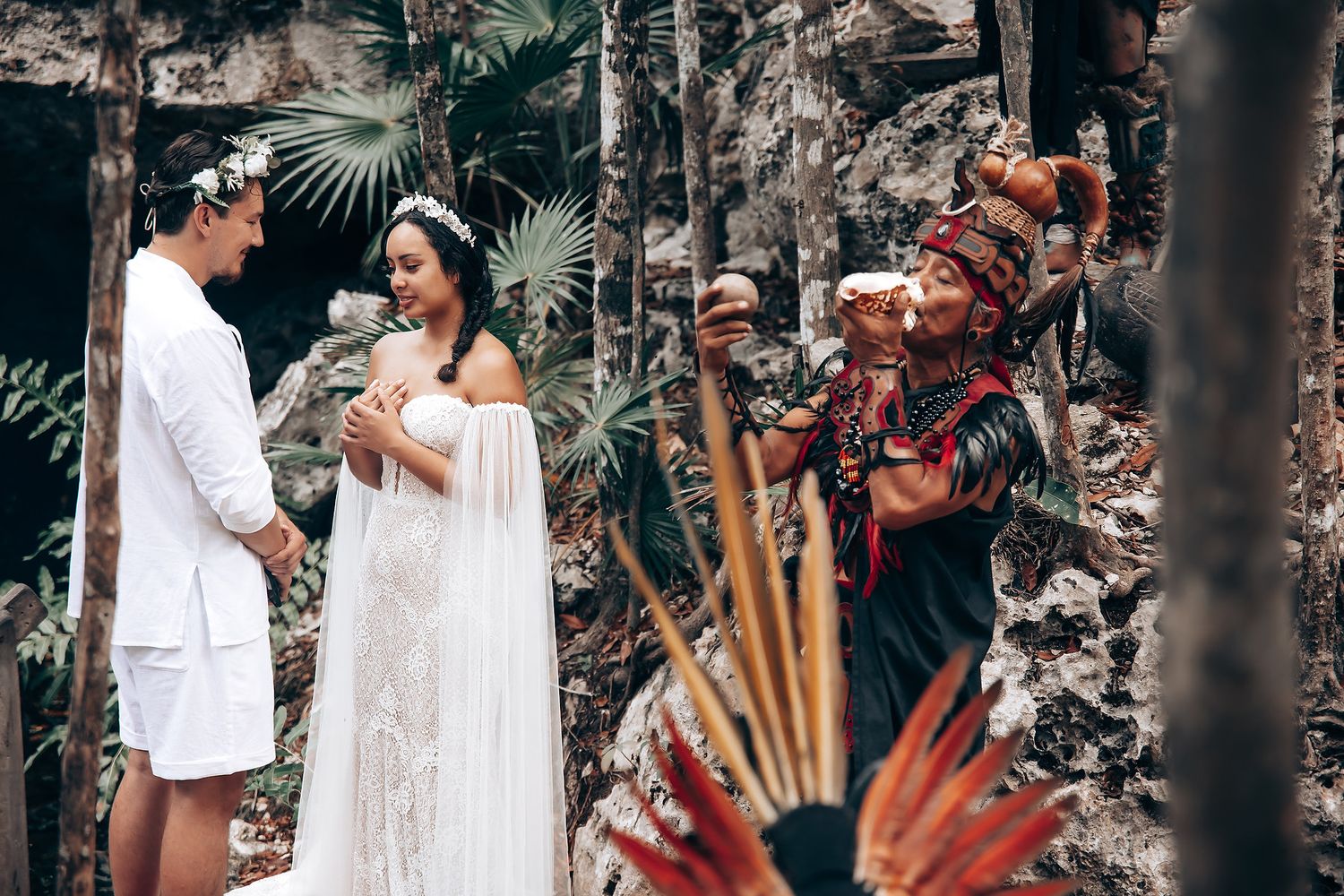 Traditional wedding ceremony in a tropical garden setting with cultural performers in traditional dress.