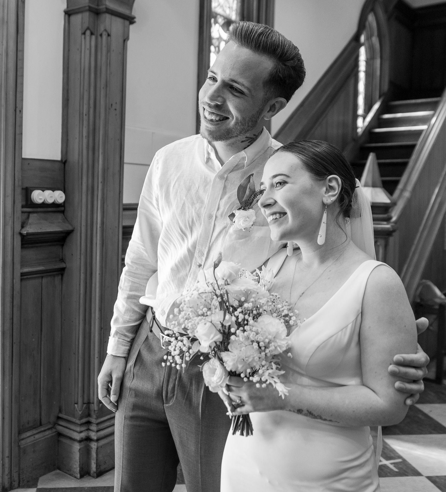 Black and white wedding portrait showing natural expressions of joy.