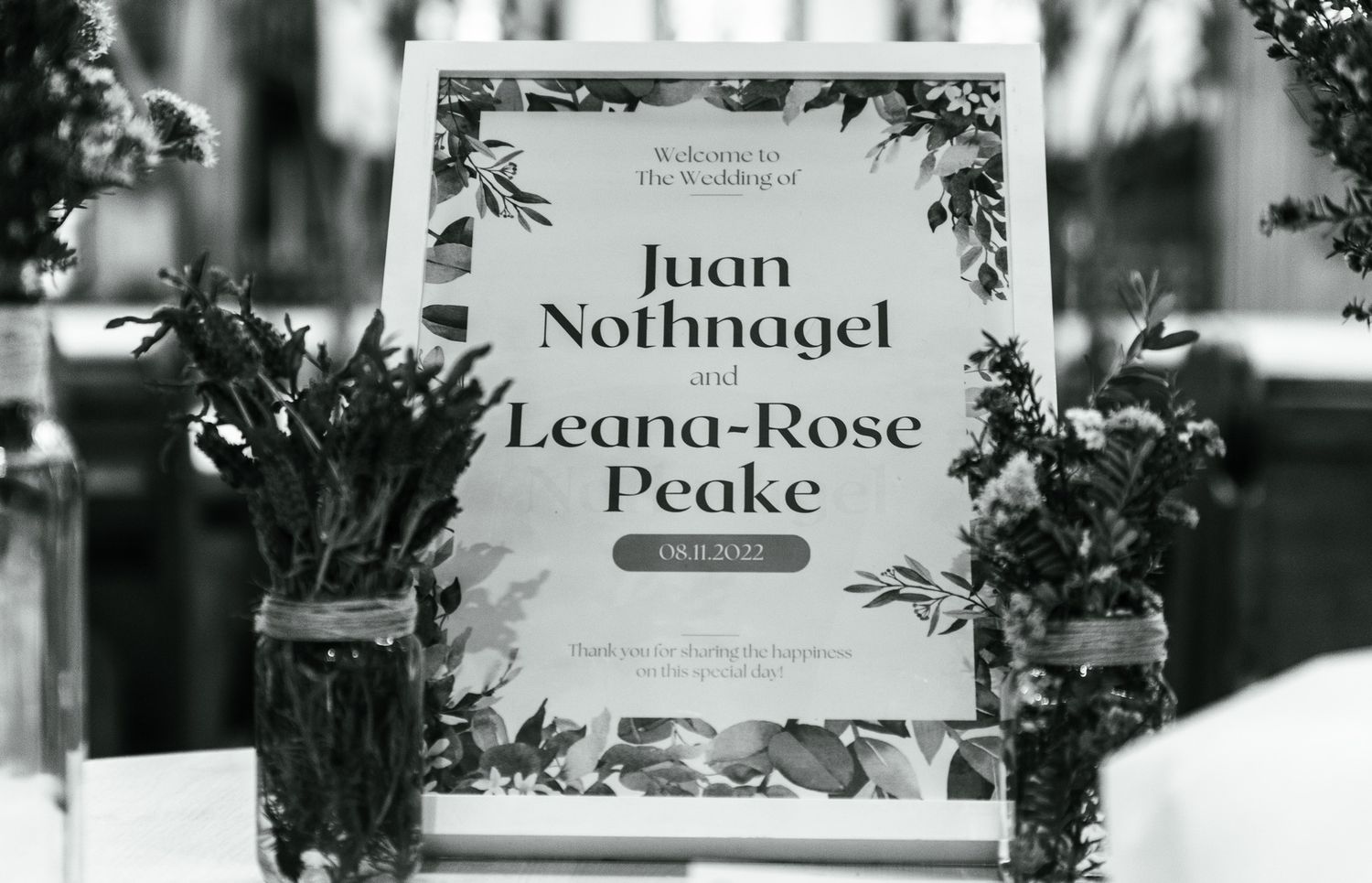 Black and white table settings with floral decorations and name cards.