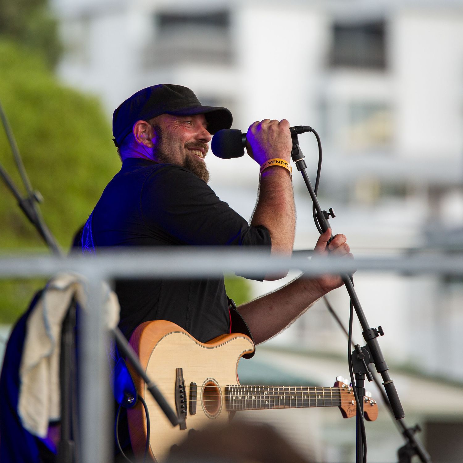 Musician performing on stage with guitar under blue lighting.