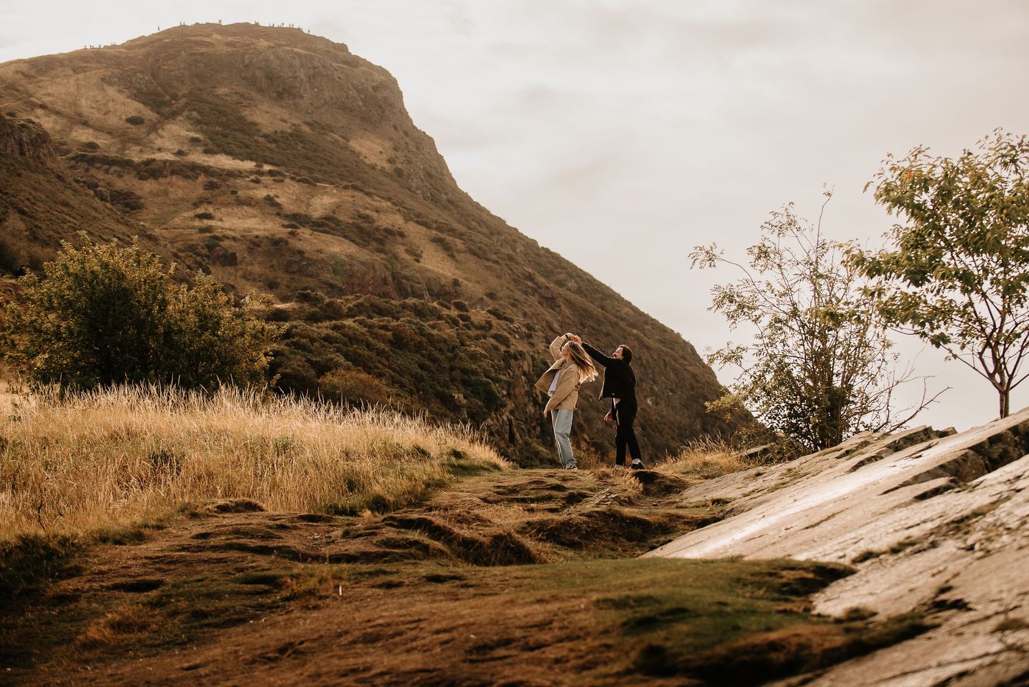Dramatic landscape view of mountain slopes with winding paths at sunset.