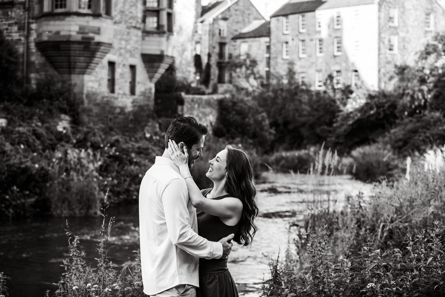 Black and white romantic portraits captured along a scenic waterway with historic architecture.