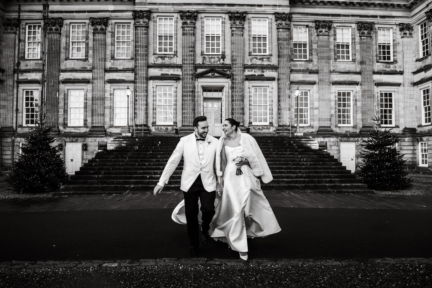 Historic mansion facade serves as backdrop for elegant wedding photography.